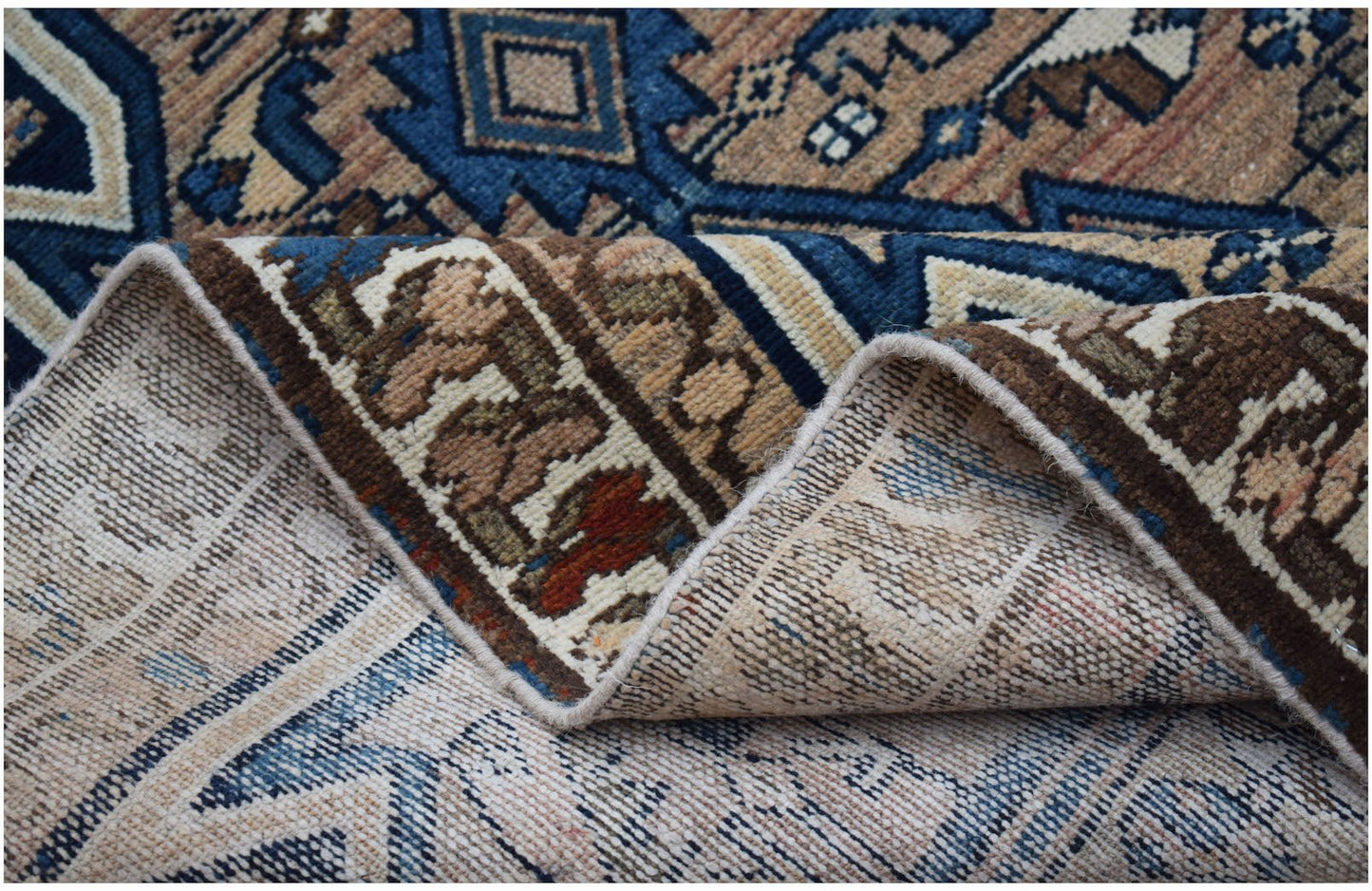 A vintage handwoven Persian Mazlaghan rug with a geometric pattern in blue and brown wool.