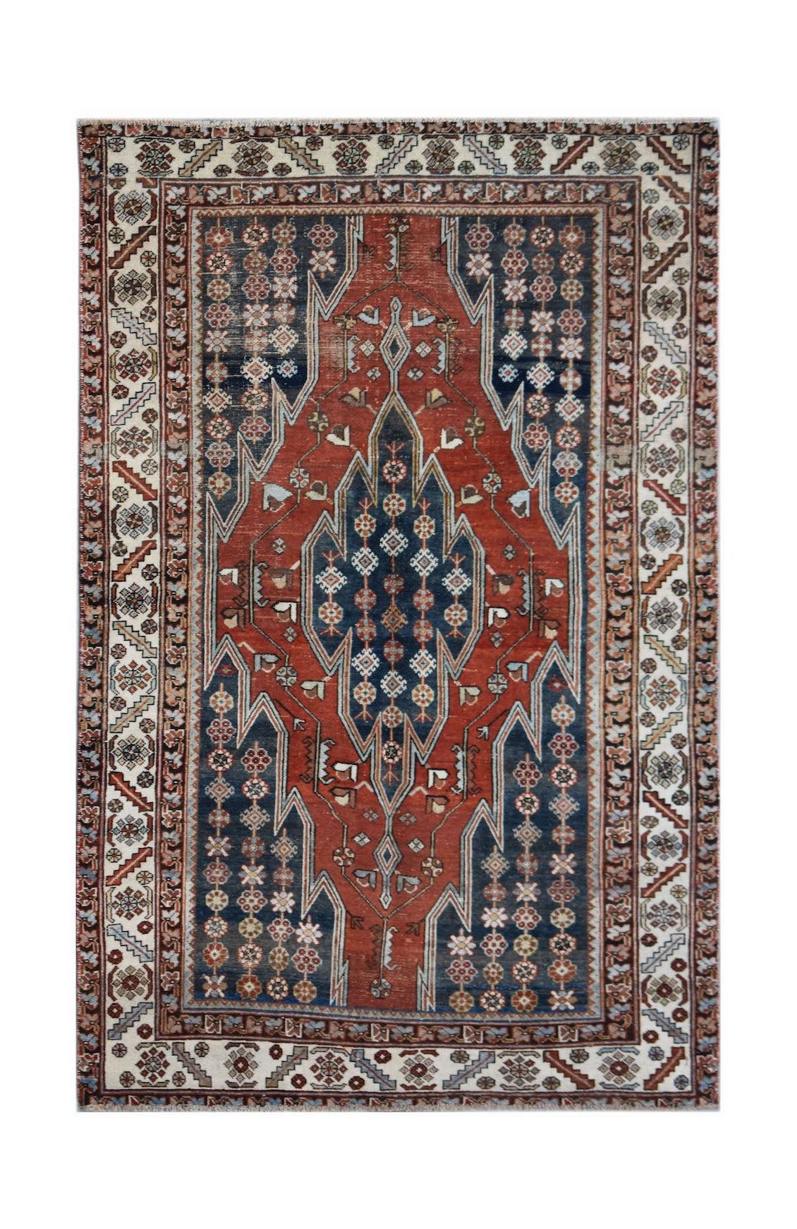 A vintage handwoven Persian Mazlaghan rug featuring a geometric medallion on a red and blue field.