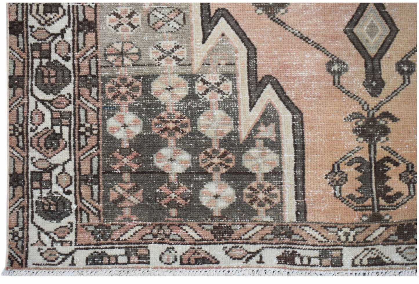 A vintage Persian Mazlaghan rug featuring geometric patterns in muted peach, grey, and brown tones.