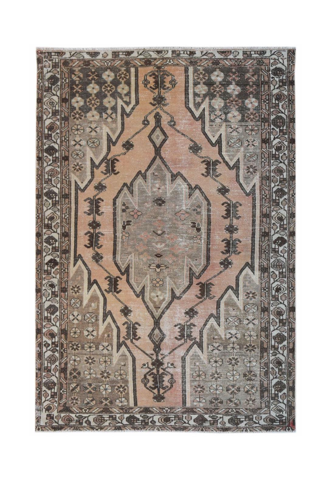A vintage Persian Mazlaghan rug featuring a geometric diamond medallion in muted peach and grey.