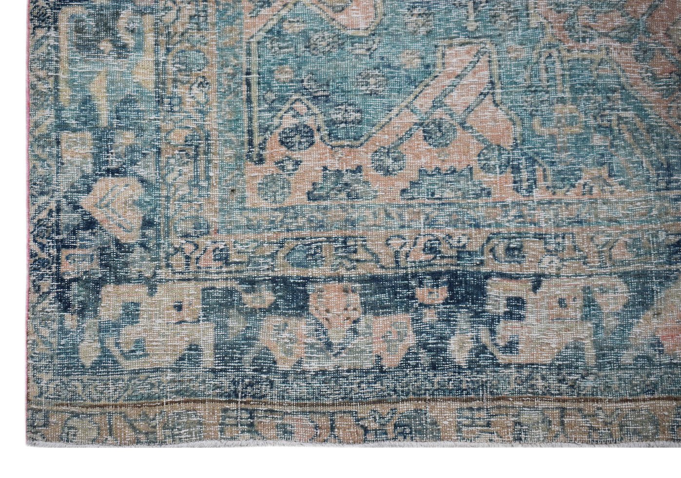 A vintage Persian Mazlaghan rug featuring a distressed teal and peach geometric floral pattern.
