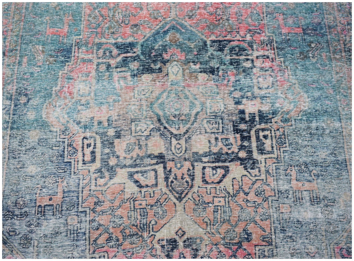 A vintage Persian Mazlaghan rug featuring a faded blue and coral geometric medallion pattern.