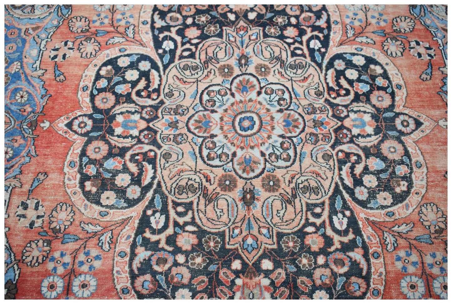 A vintage Persian Moud rug featuring a central floral medallion in shades of red, blue, and cream.