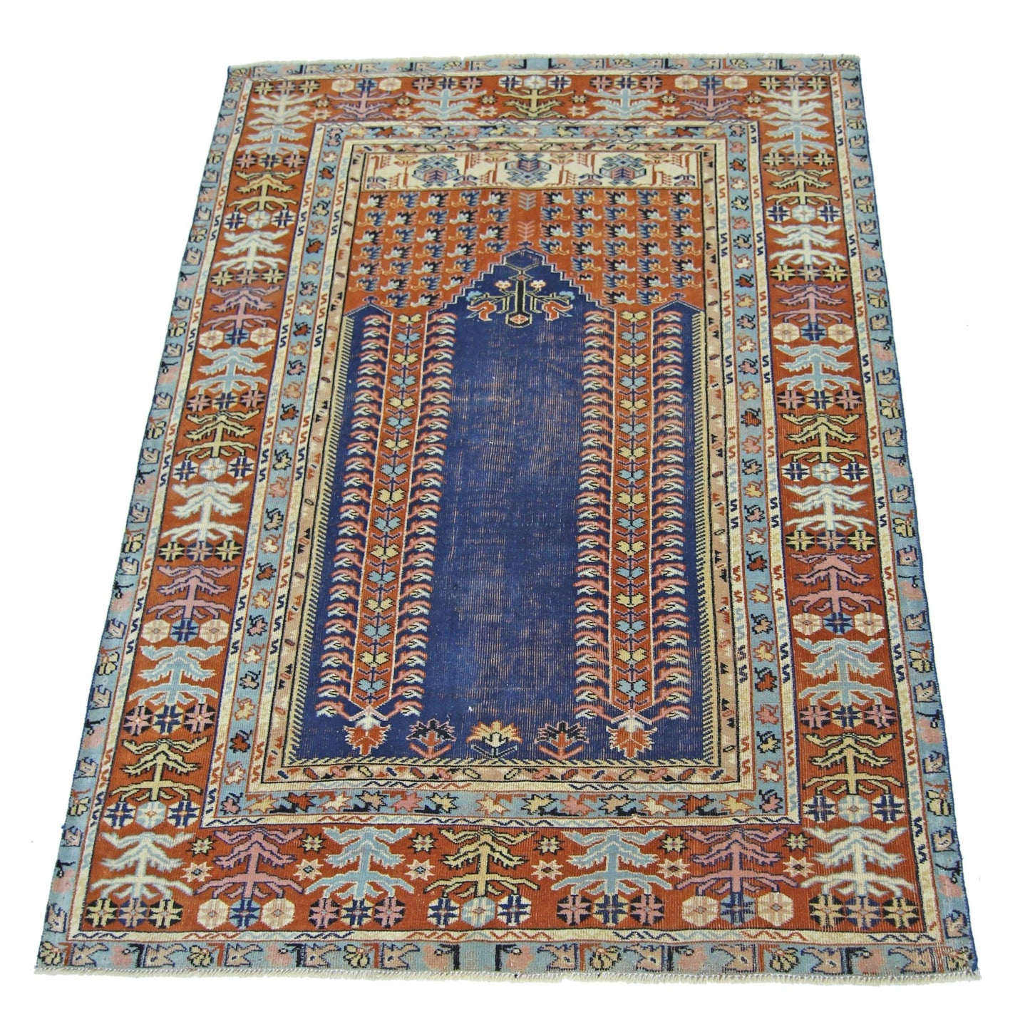A vintage Persian prayer rug featuring a central blue mihrab design on a rust-colored field.