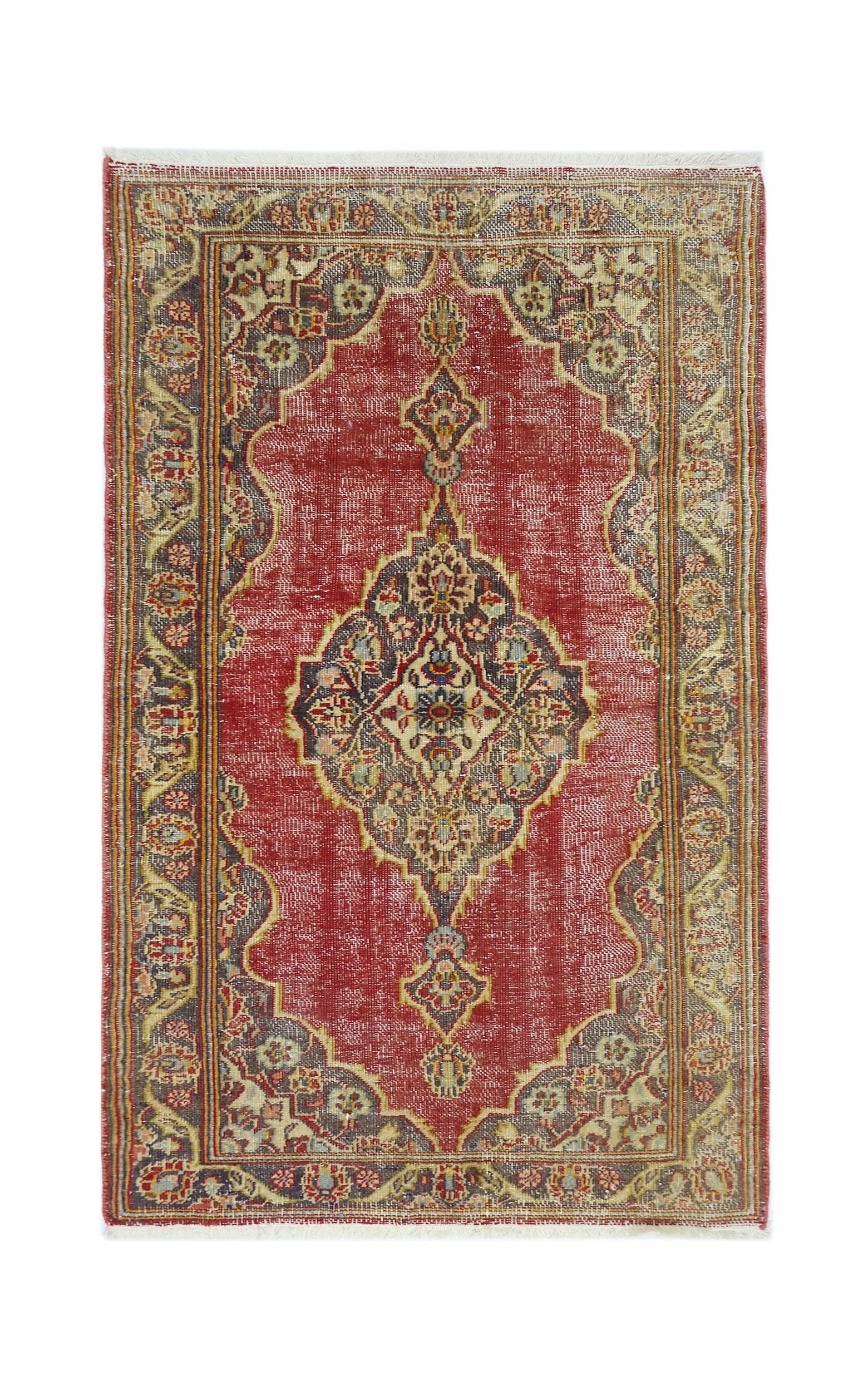 A vintage handmade Persian rug featuring a central medallion on a red field with ornate borders.