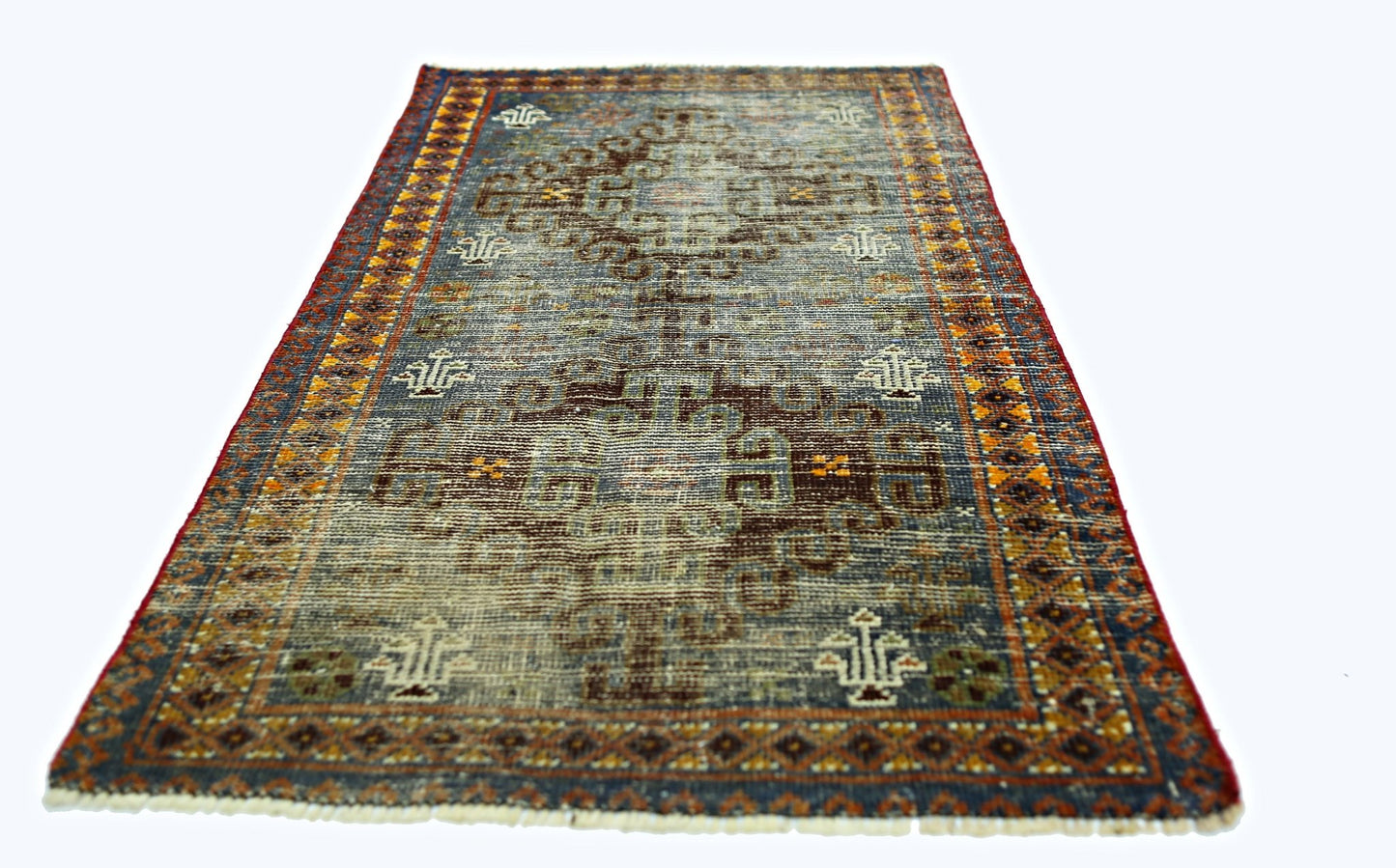 A vintage handmade Persian rug featuring a geometric pattern in blue, brown, and orange tones.