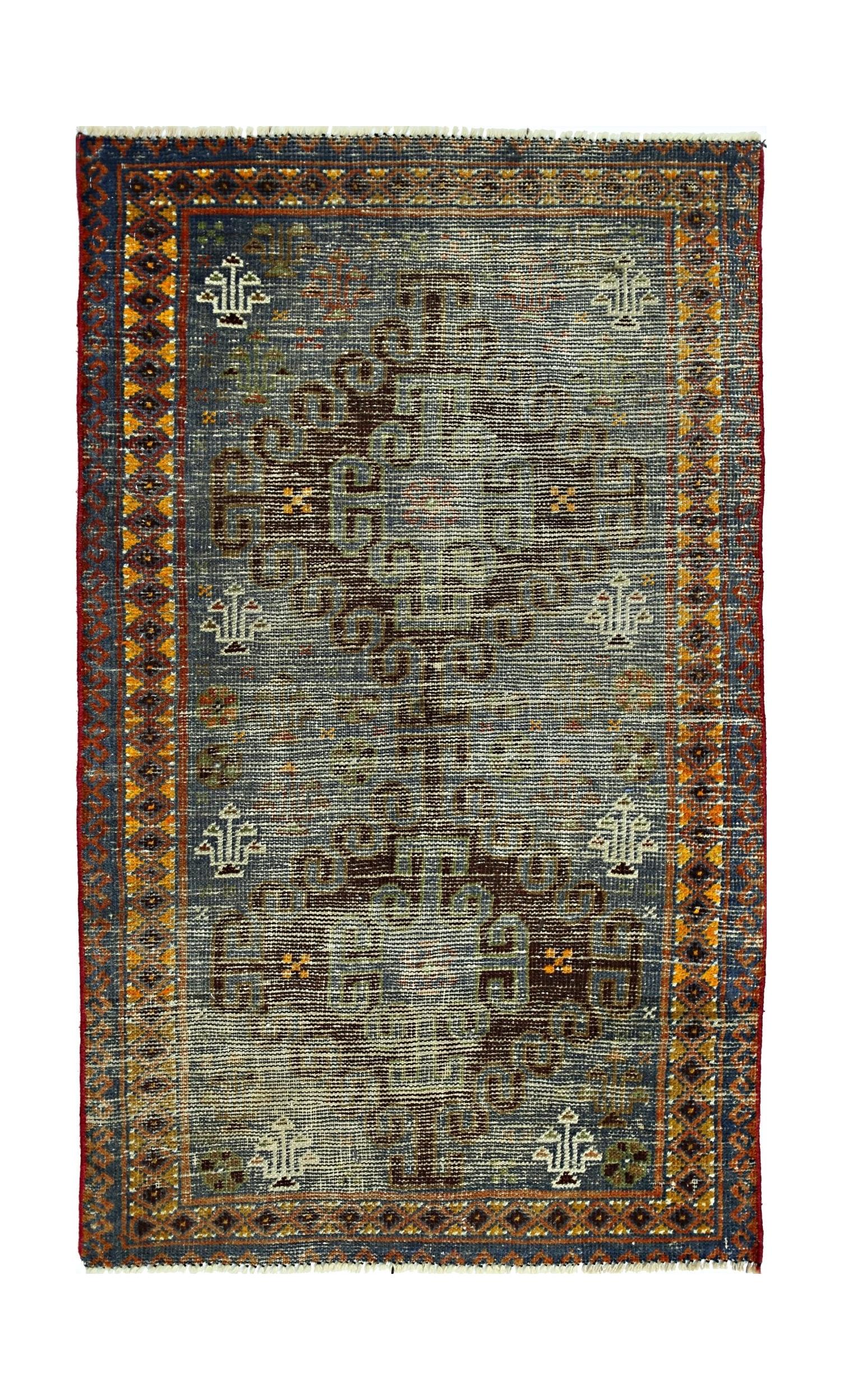 A vintage handmade Persian rug featuring a central geometric motif on a blue field.