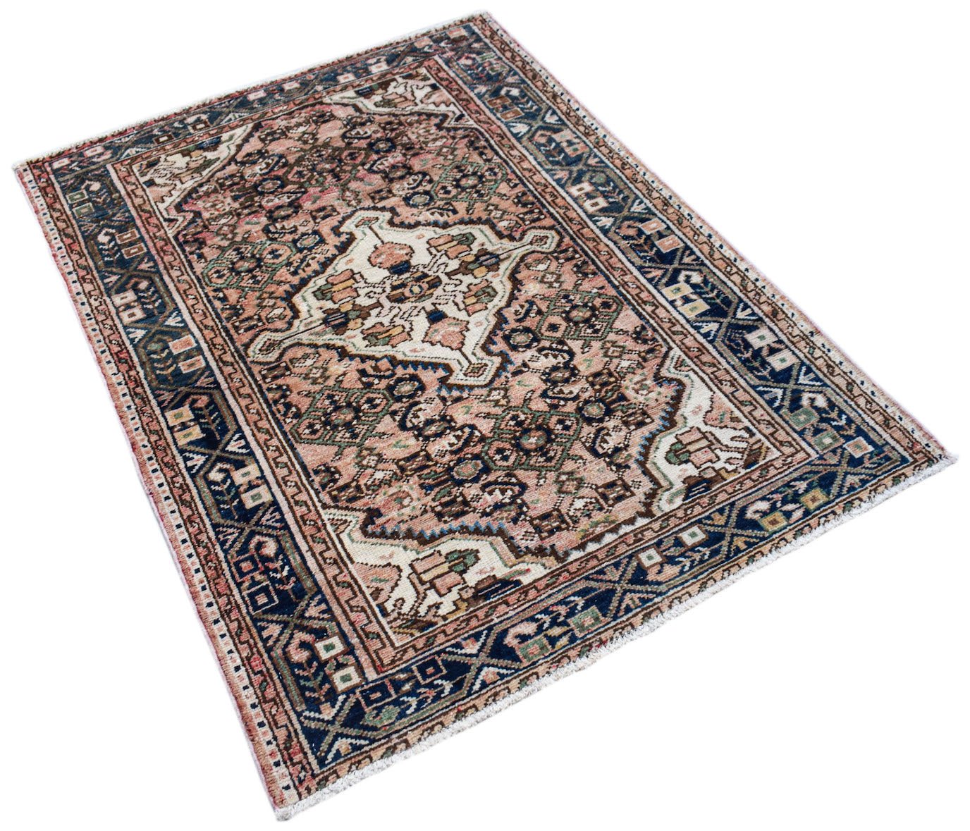 A handwoven vintage Persian rug featuring a central medallion on a faded pink and blue field.