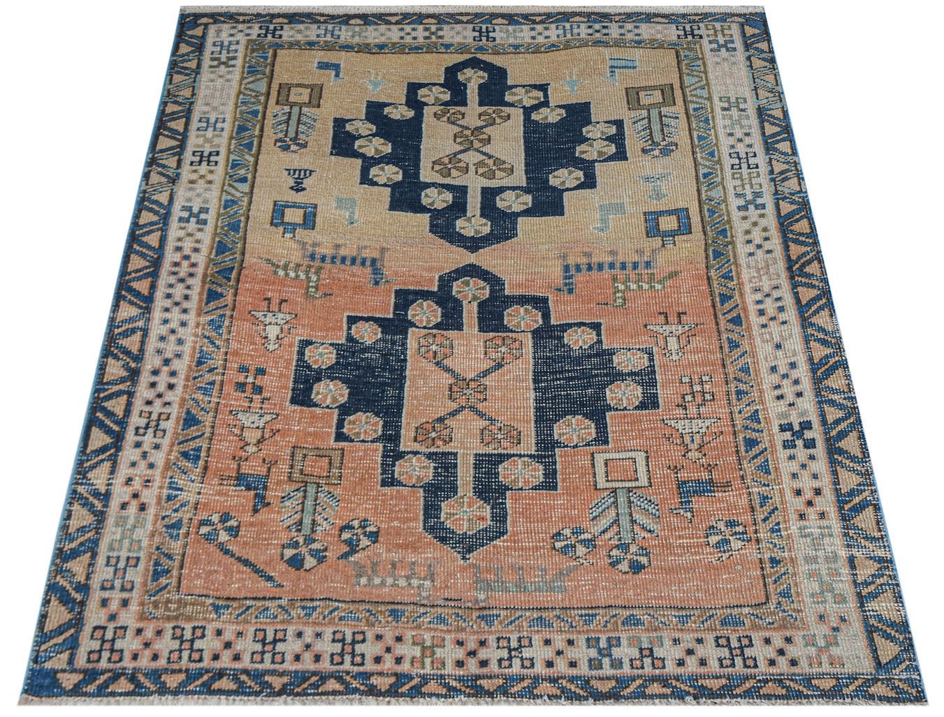 Vintage Persian rug with geometric patterns in navy and peach.