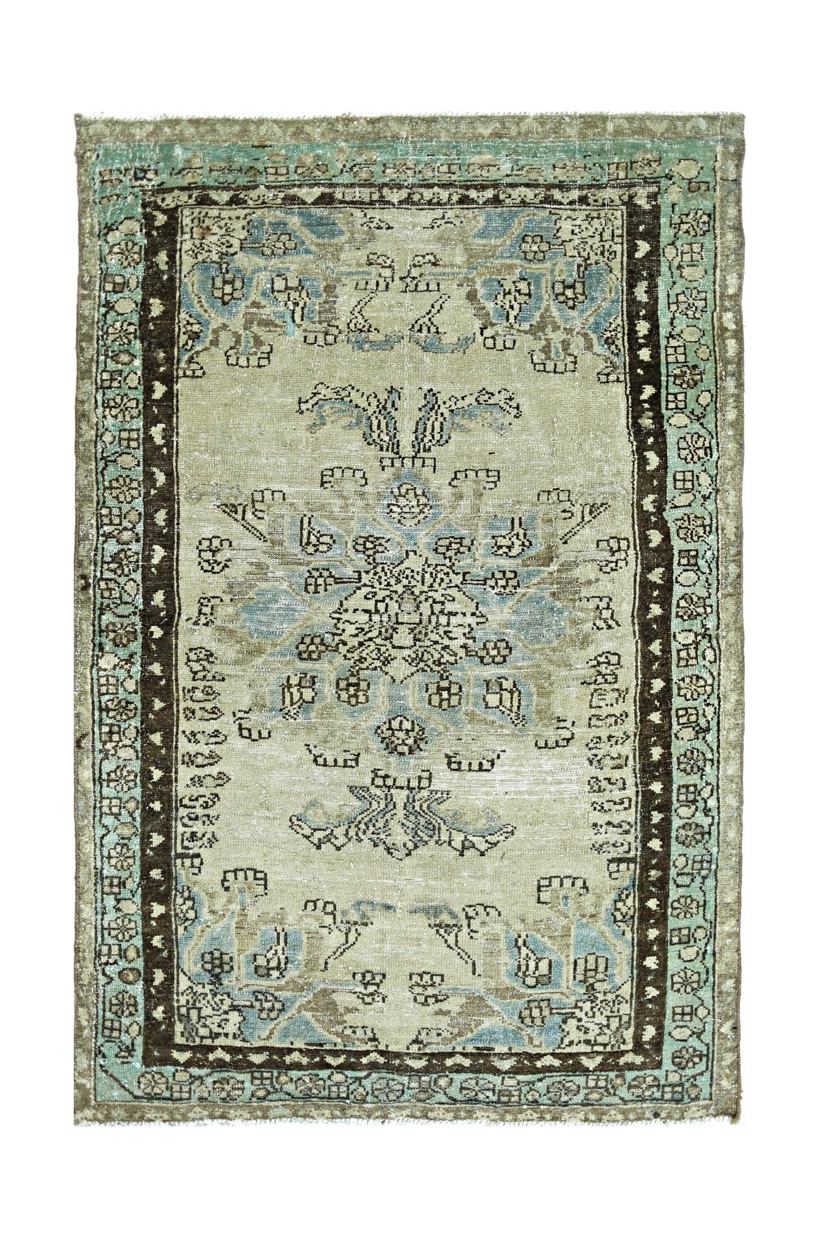 A vintage handmade Persian rug featuring a central floral medallion in blue and beige tones.
