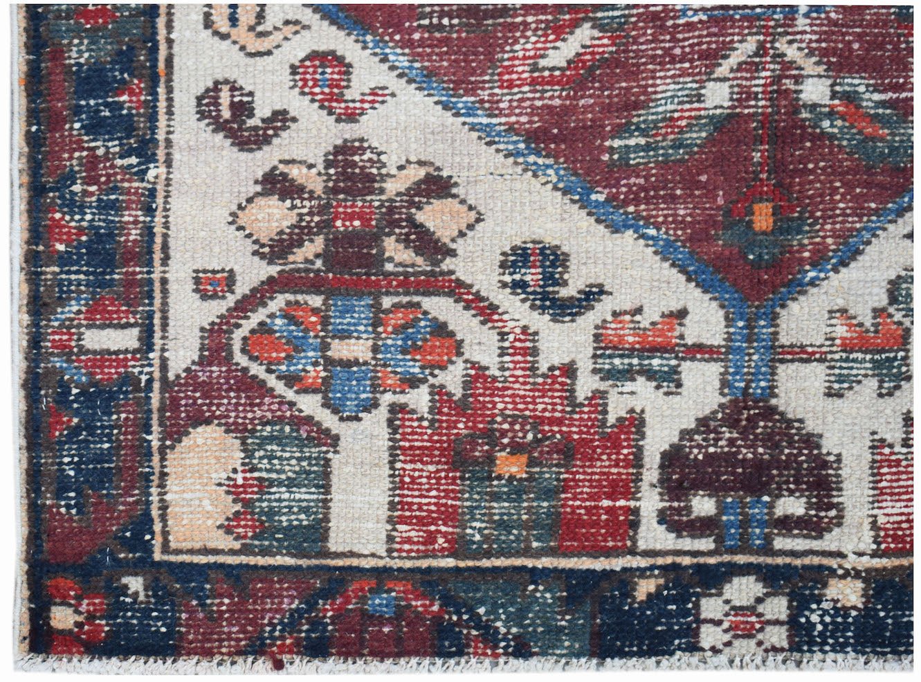 A handwoven vintage Persian rug featuring intricate geometric floral patterns in red and blue.