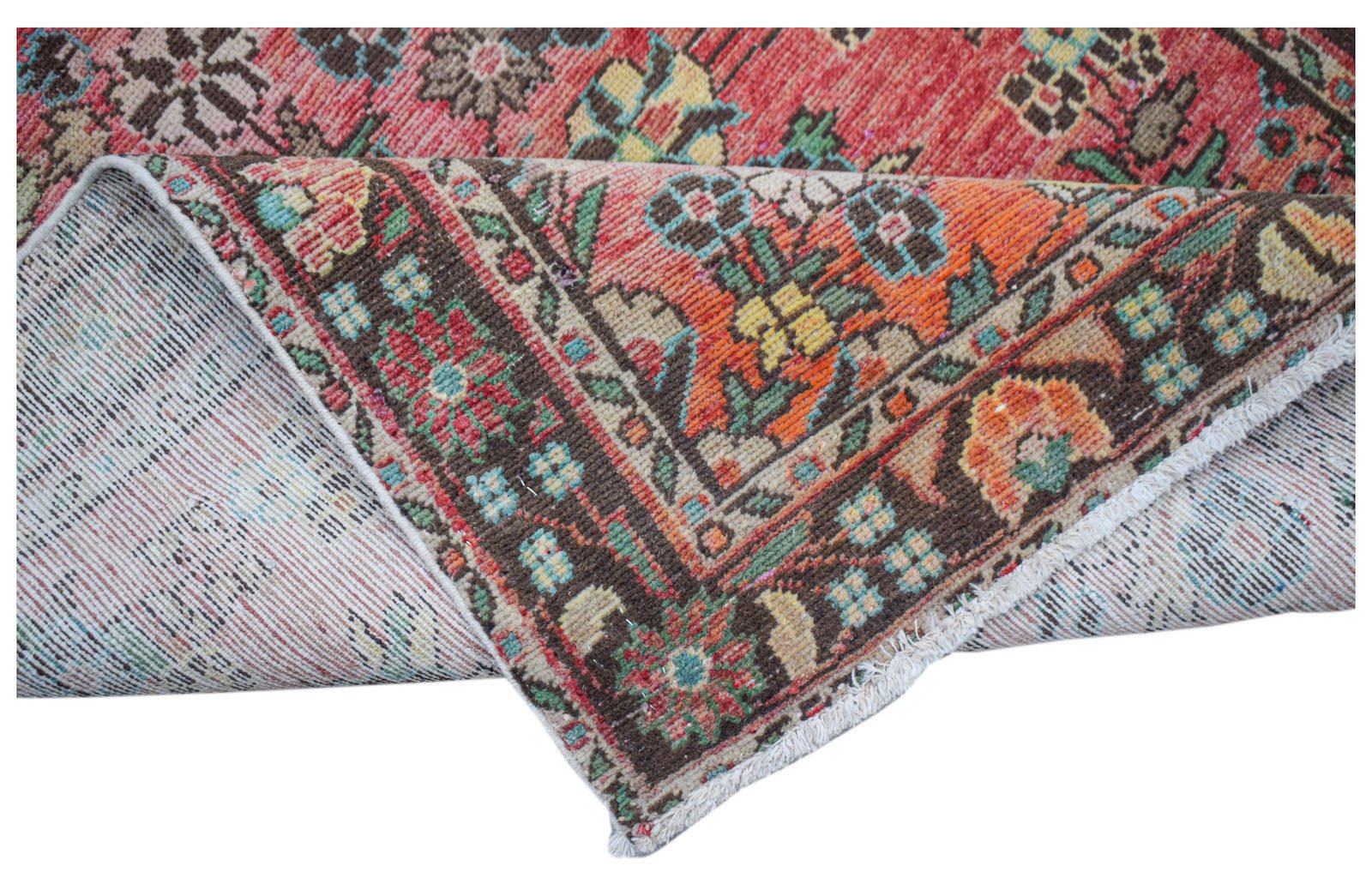 A handwoven vintage Persian rug featuring a floral pattern in red, orange, and brown tones.