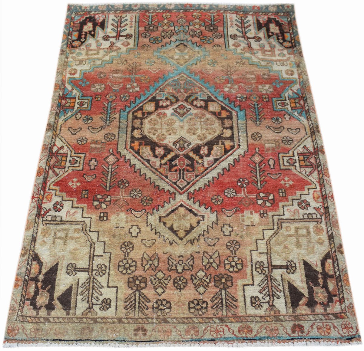 A handwoven vintage Persian rug featuring a geometric medallion pattern in red and beige tones.