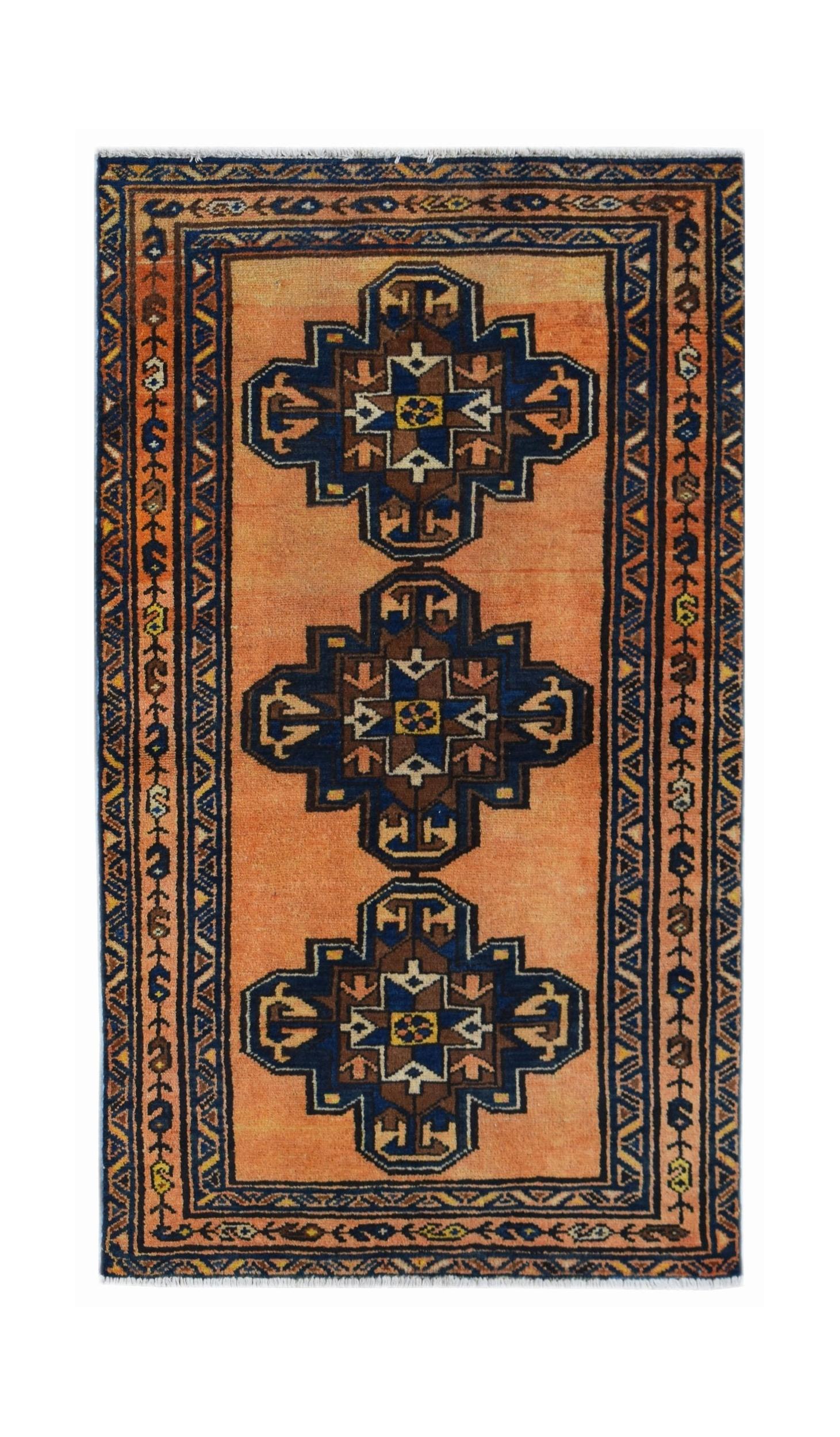 A vintage Persian rug featuring three dark blue geometric medallions on an orange field.