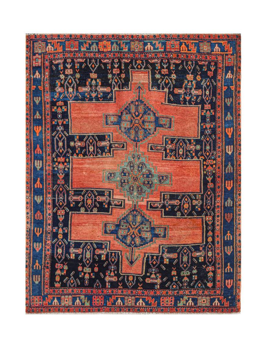 A handwoven vintage Persian rug featuring a geometric pattern in shades of orange and navy blue.