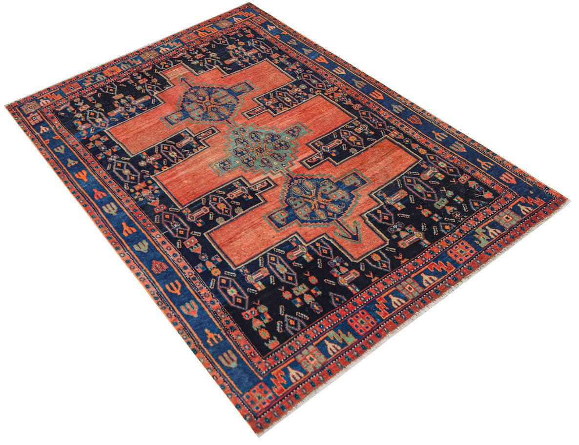 Vintage Persian rug with a central medallion and geometric patterns in red and blue.