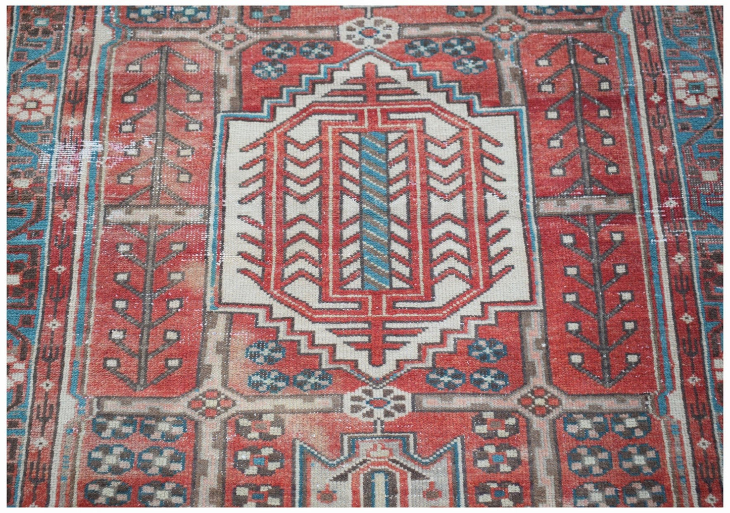 A vintage handwoven Persian Hamadan rug featuring a geometric central medallion in red and blue.