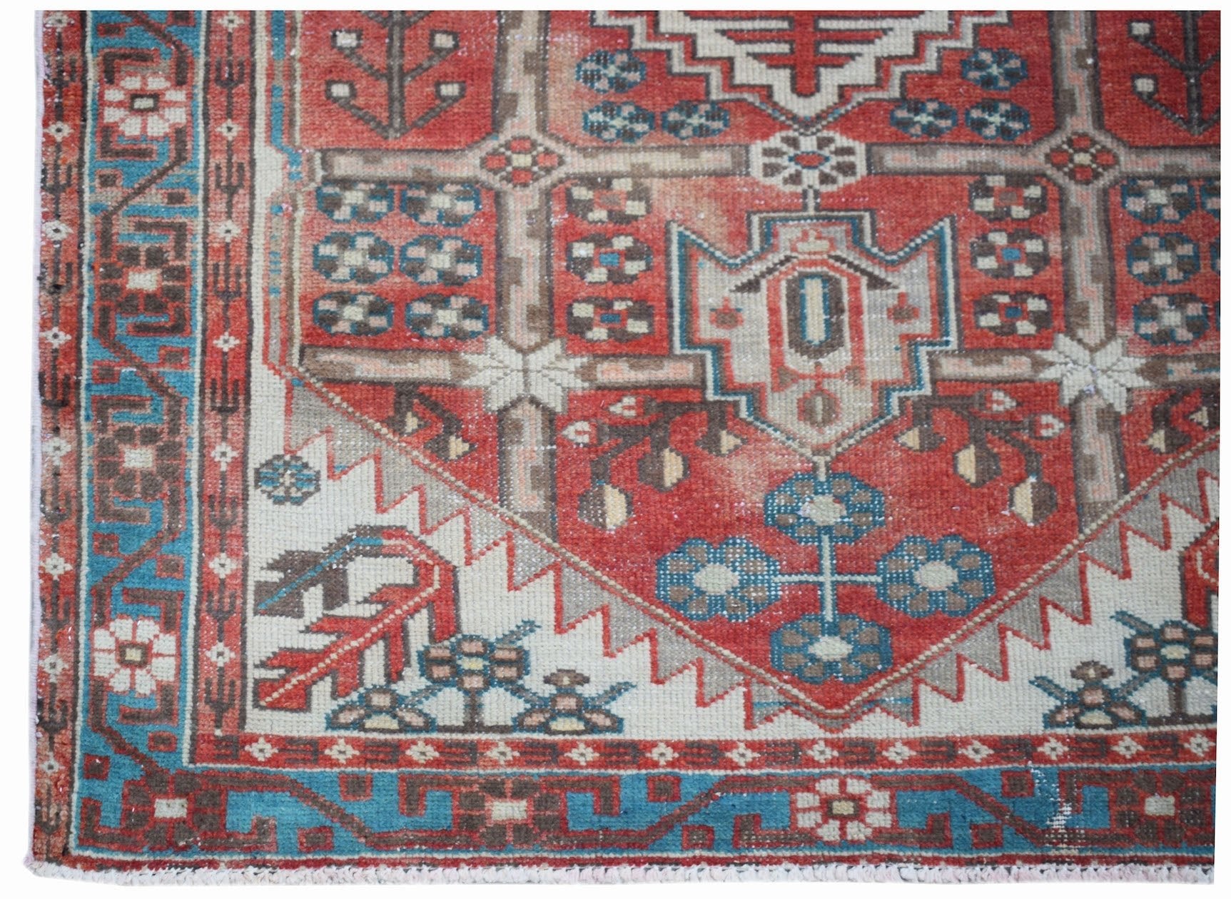 A vintage handwoven Persian Hamadan rug featuring a geometric red, blue, and cream pattern.