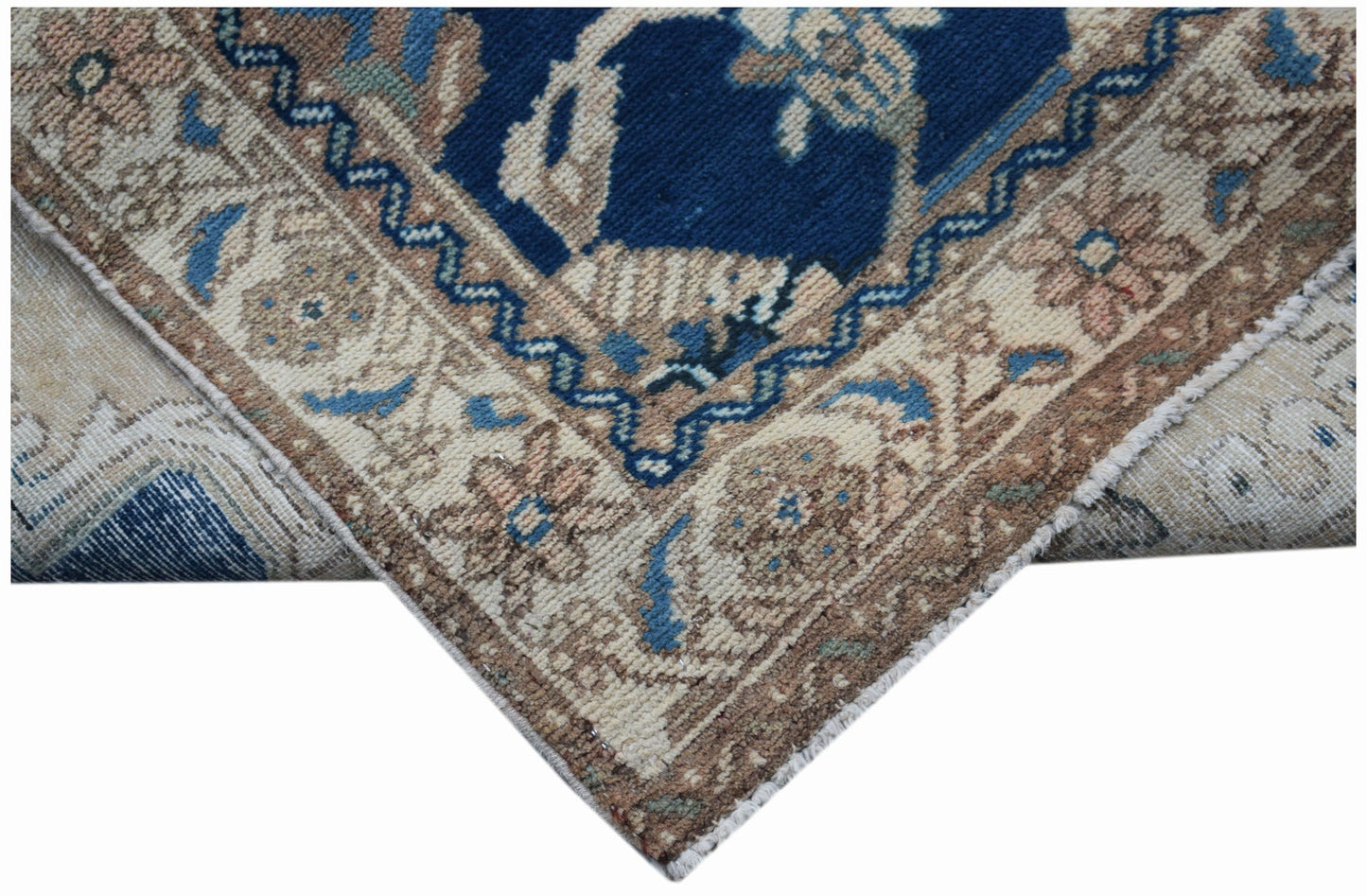 A vintage Persian Sarouk rug featuring a blue field with floral patterns and a beige border.