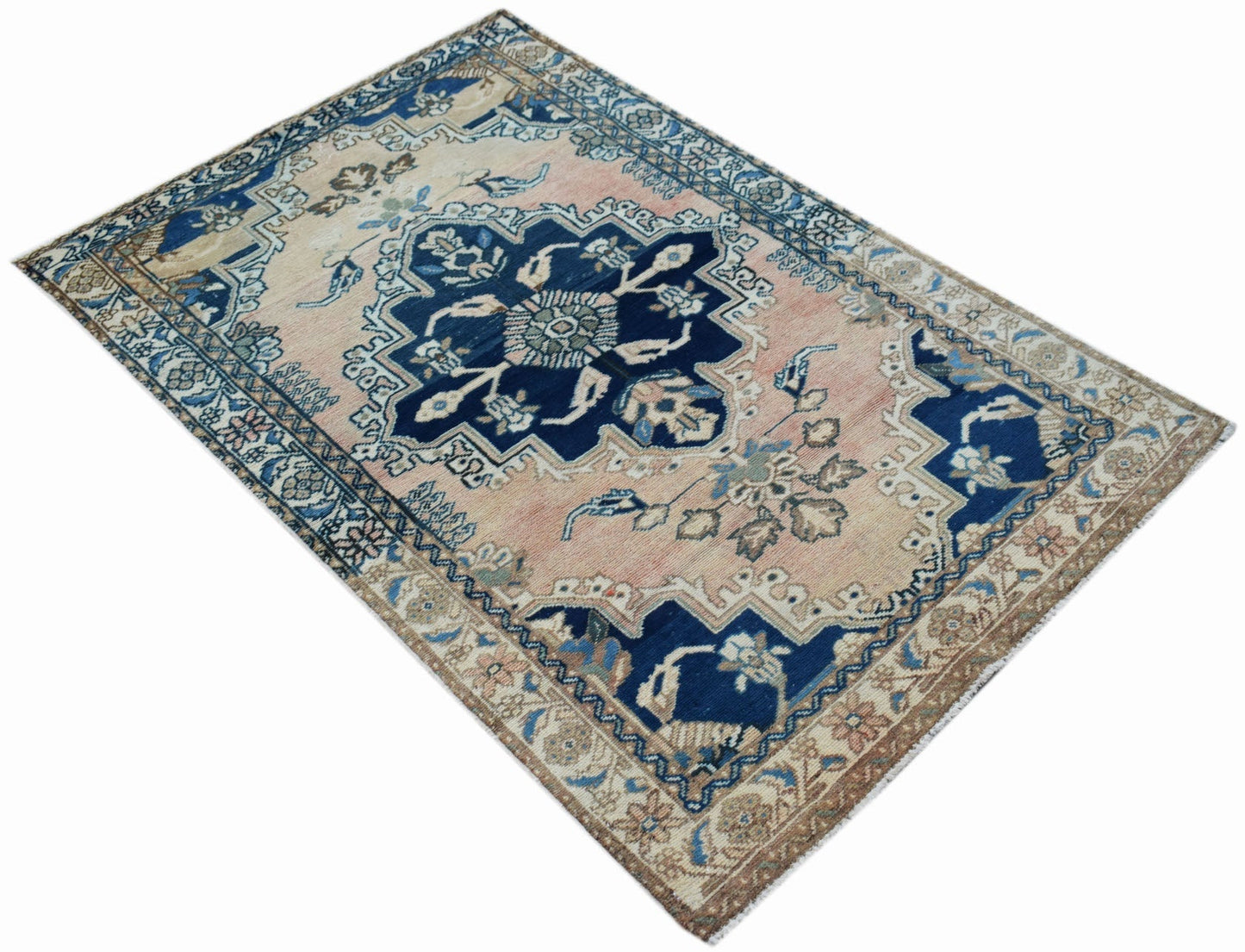 A vintage Persian Sarouk rug featuring a central floral medallion on a faded pink and blue field.
