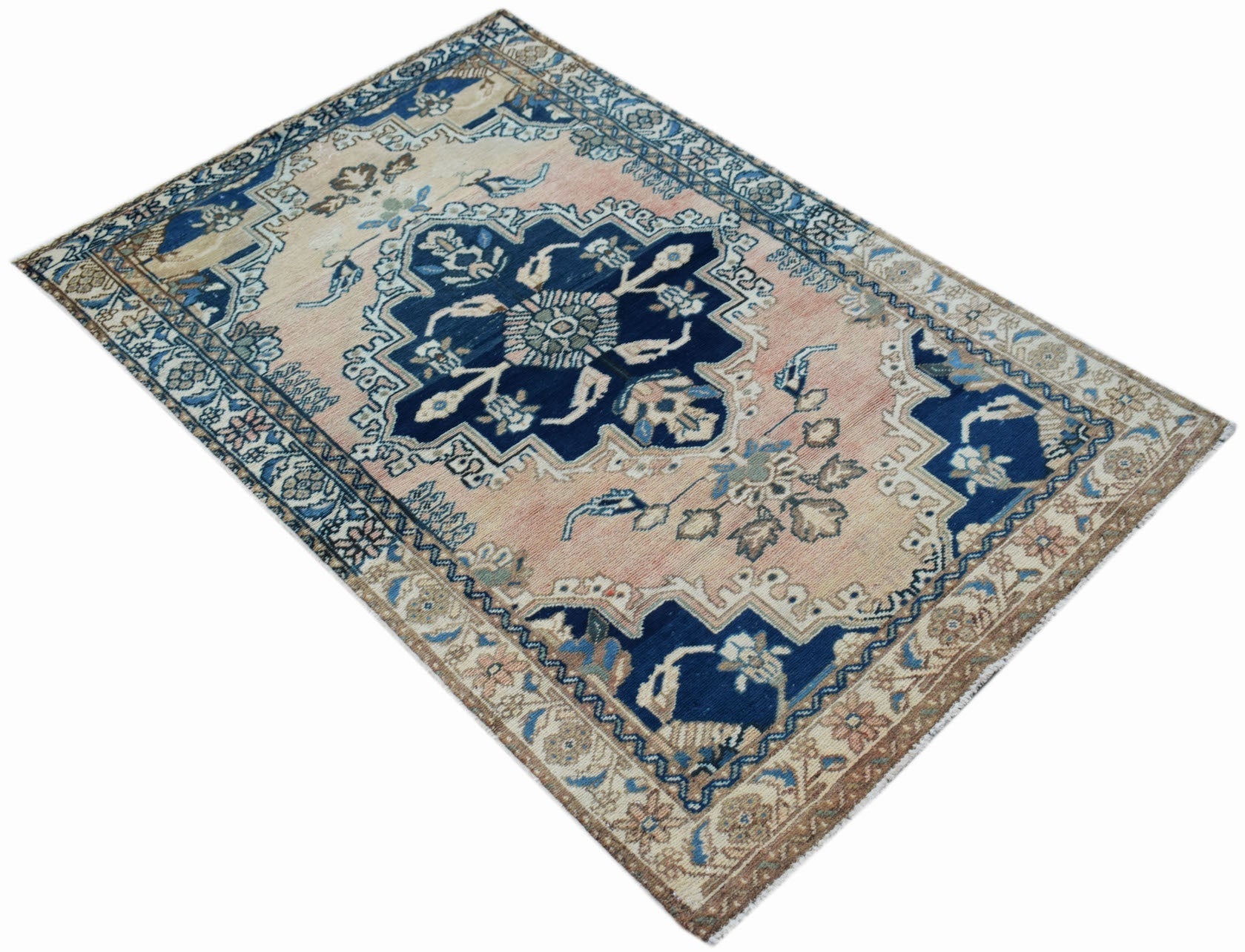 A vintage Persian Sarouk rug featuring a central floral medallion on a faded pink and blue field.