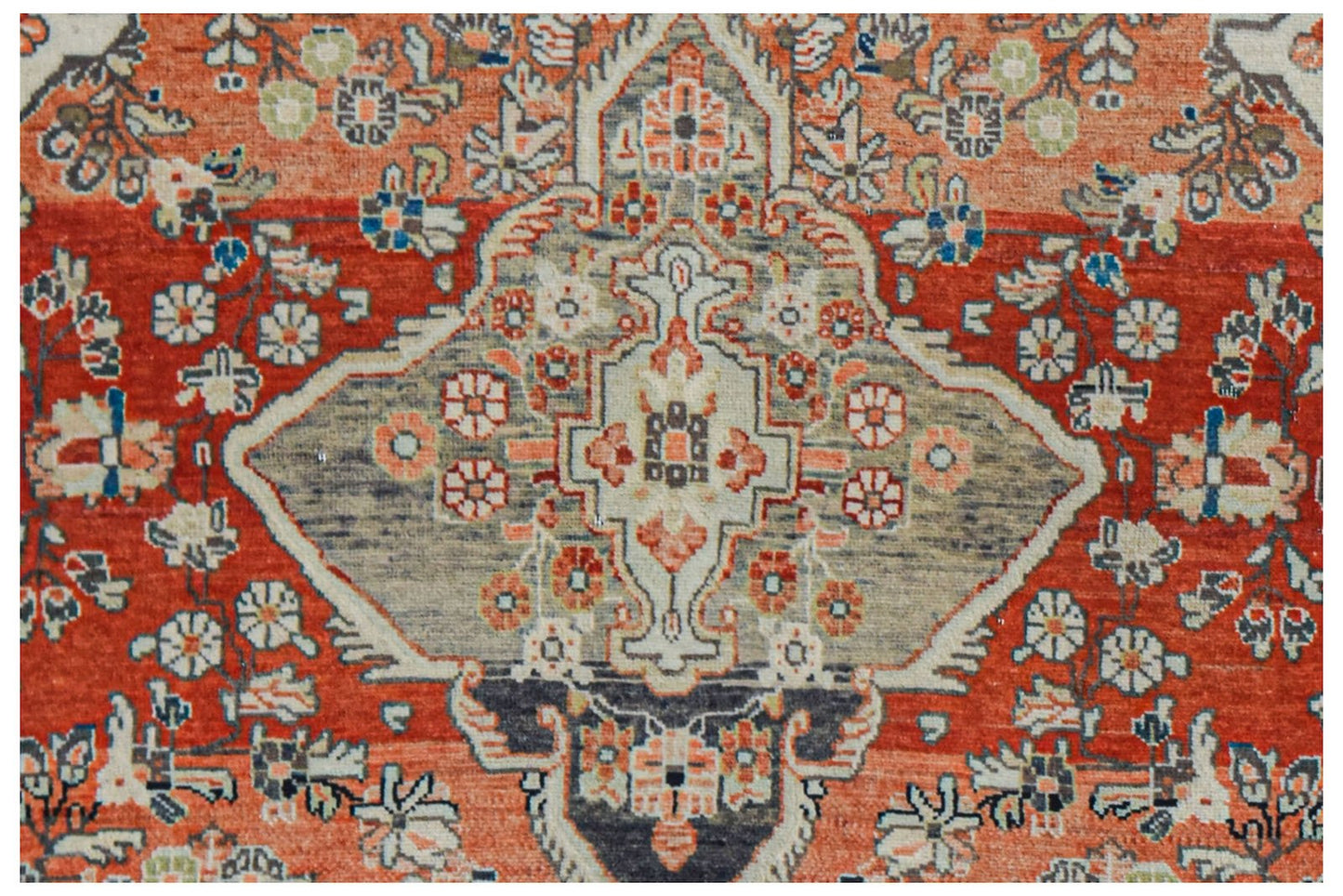 Vintage Persian rug with a central medallion and floral motifs in red and grey.