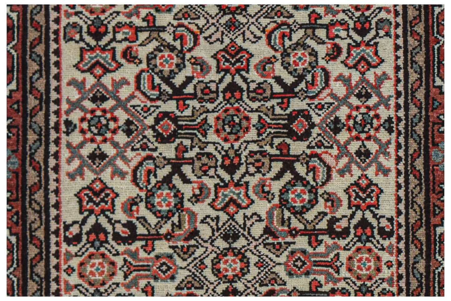 A vintage handwoven Persian rug featuring a detailed geometric floral pattern in red and black.