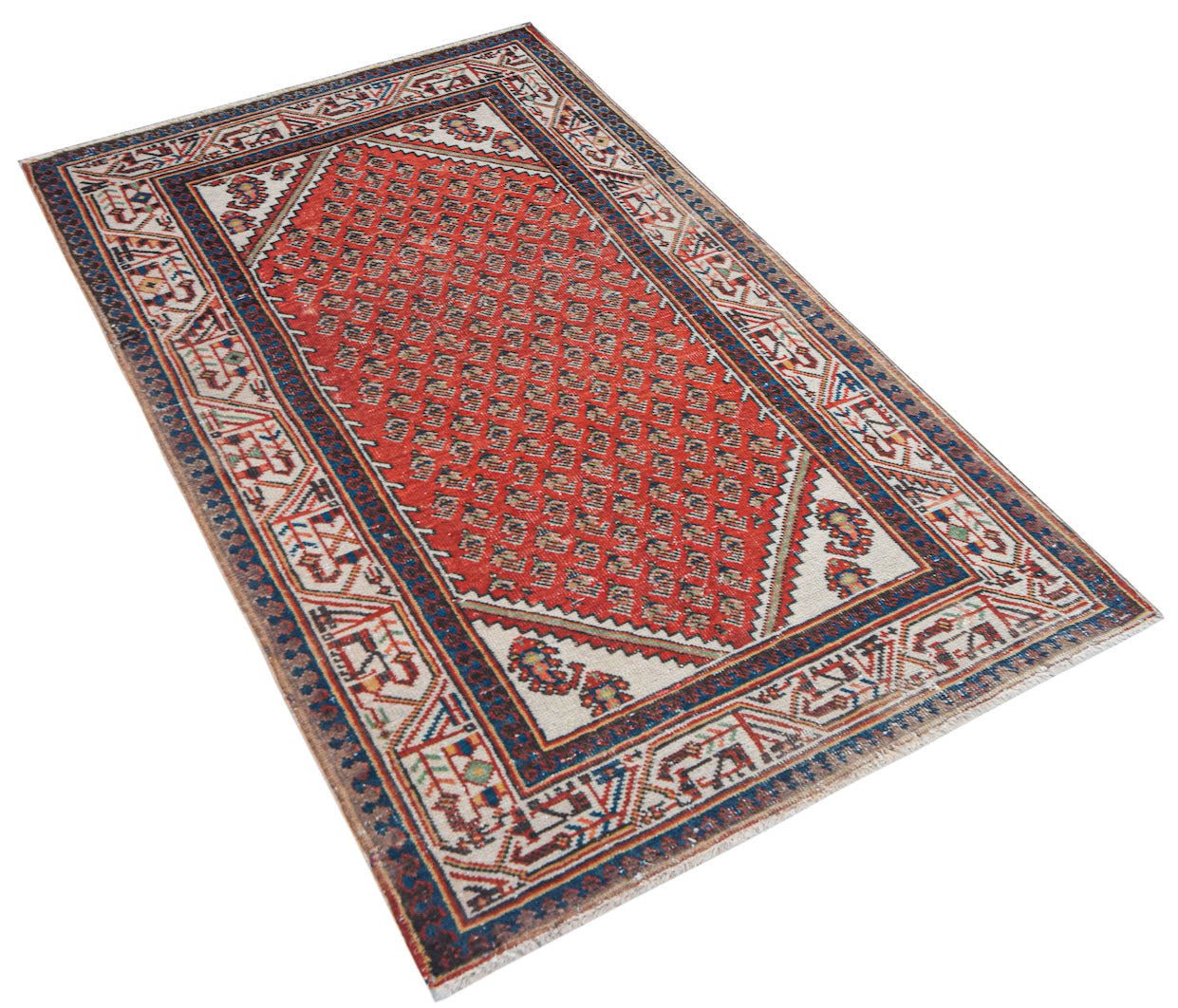 Vintage Persian rug with a red geometric pattern and cream and blue borders.