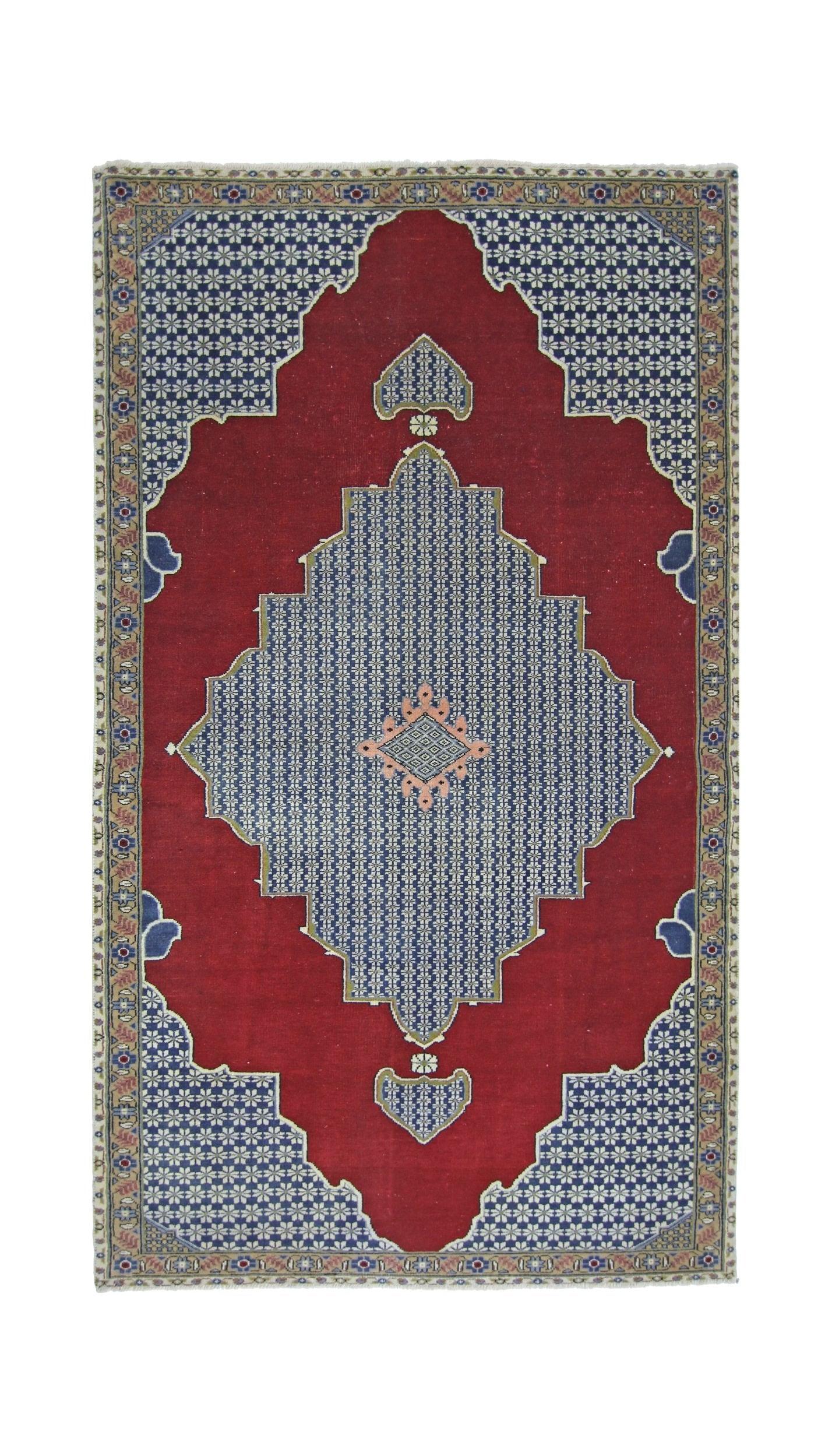 A vintage Persian rug featuring a blue diamond medallion on a red field with floral patterns.