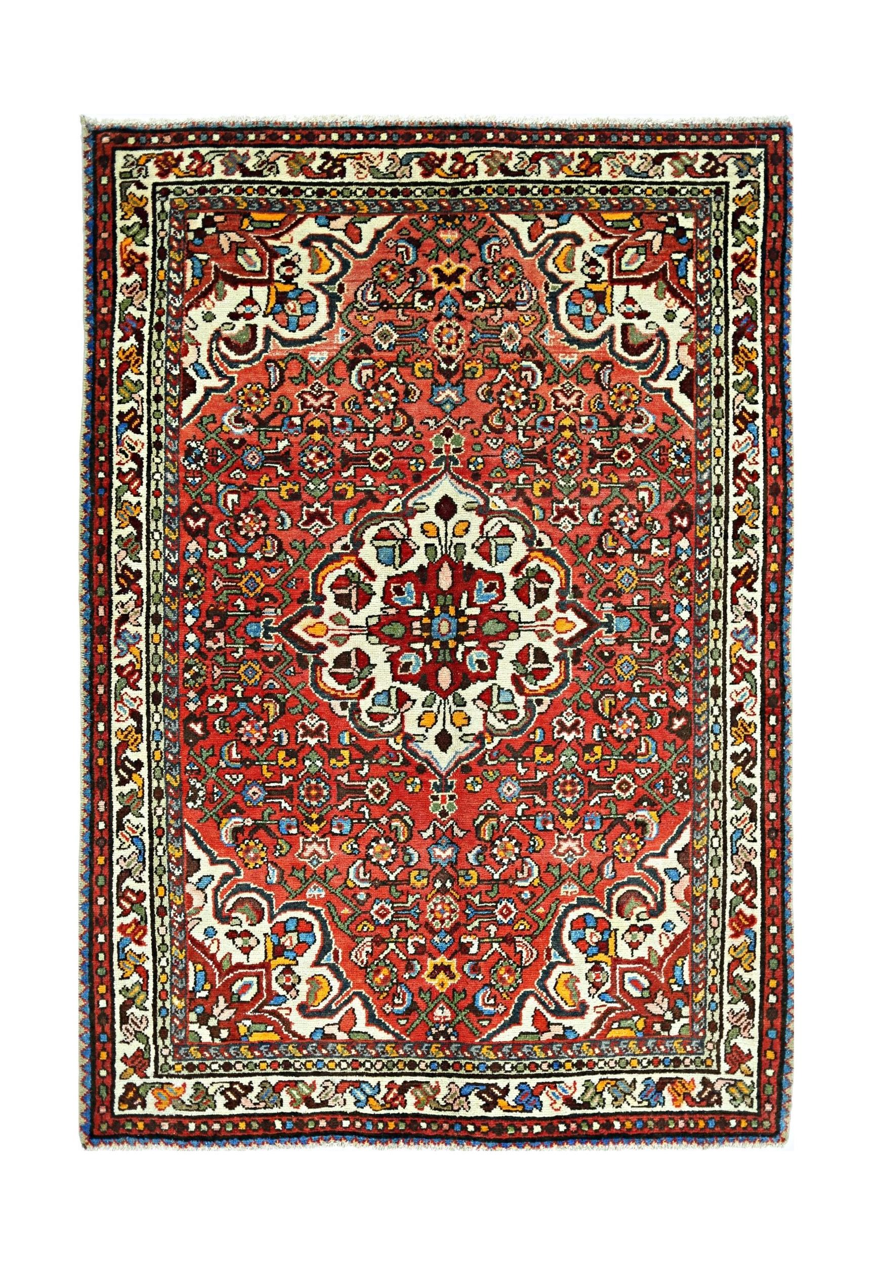 A vintage Persian Sarouk rug featuring a central floral medallion on a vibrant red field.
