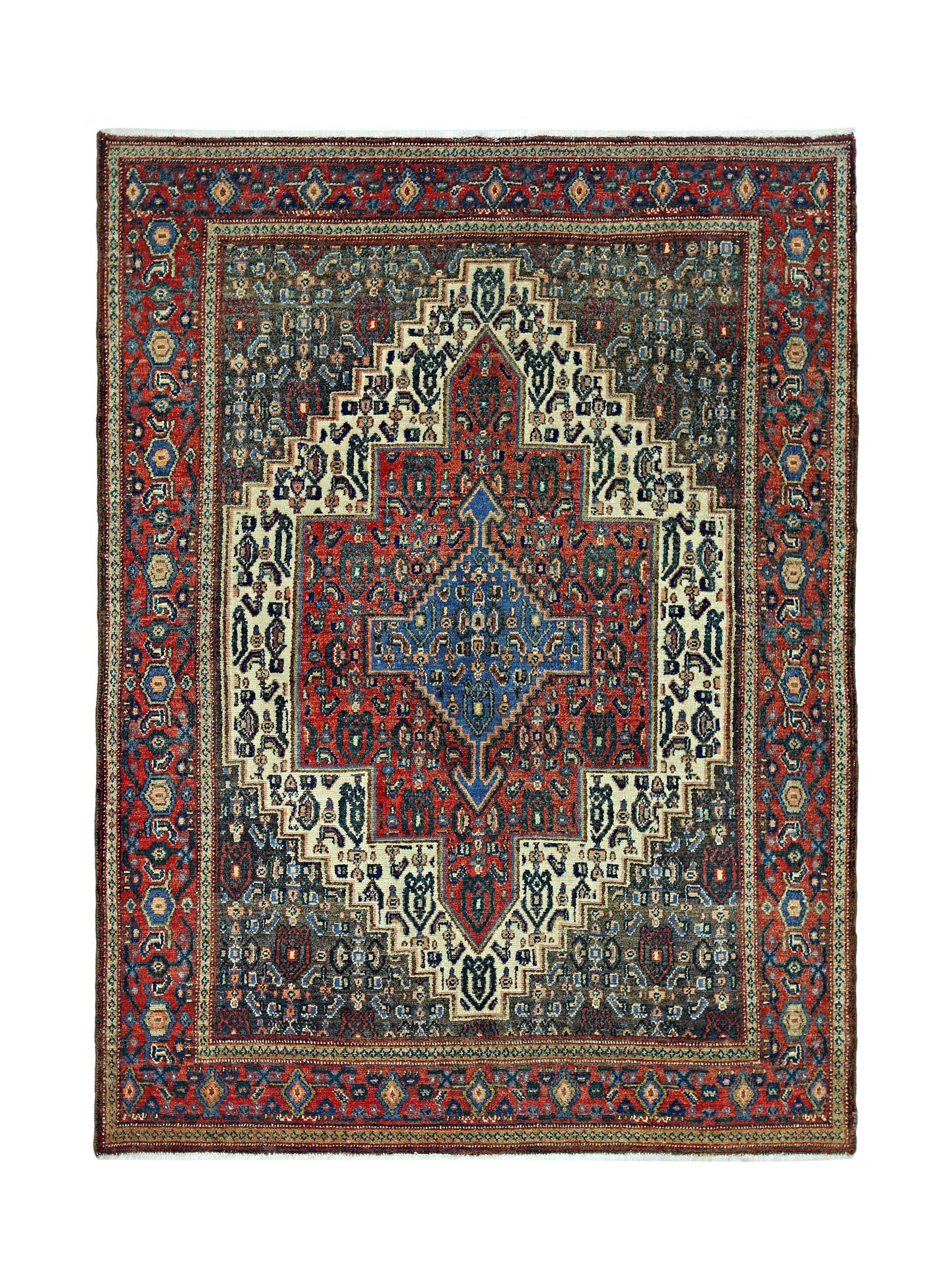 A vintage handmade Persian Senneh rug featuring a geometric medallion pattern in red and blue.