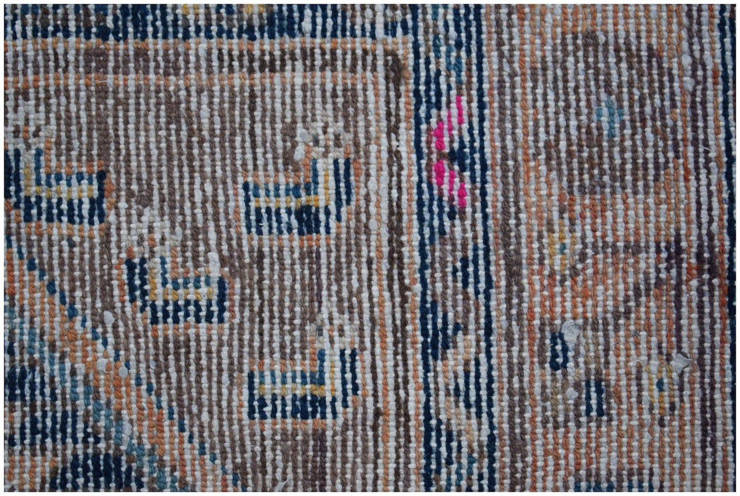 A close-up of a vintage Persian rug featuring geometric patterns in blue, orange, and white wool.