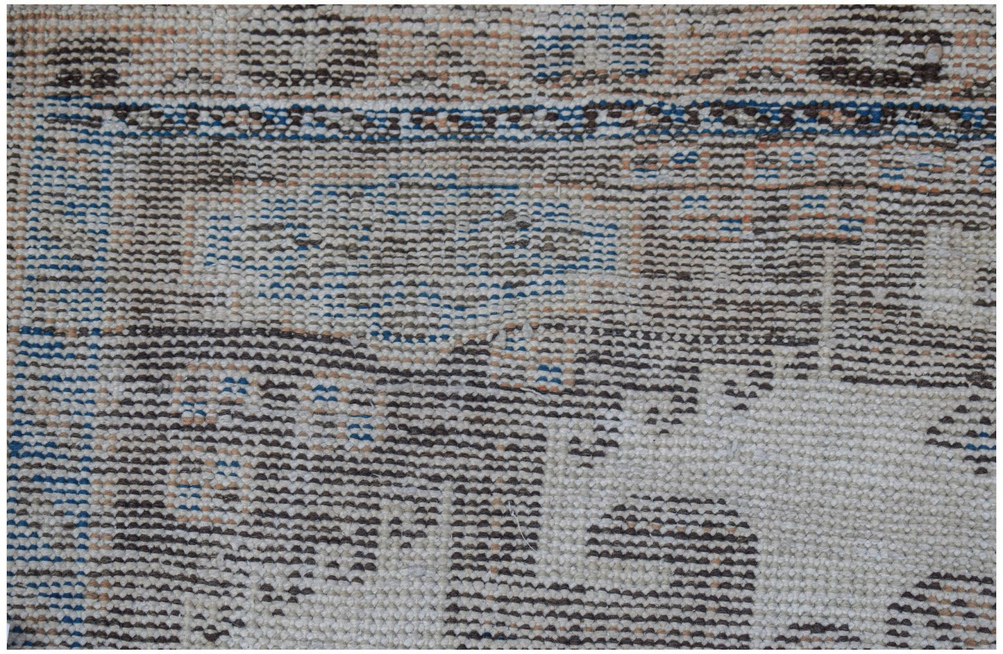 A close-up view of a handwoven vintage Persian rug featuring intricate geometric patterns in wool.