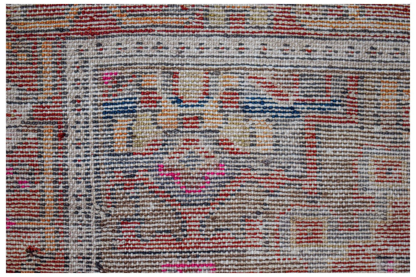 A close-up of a handwoven vintage Persian rug featuring intricate geometric patterns in wool.