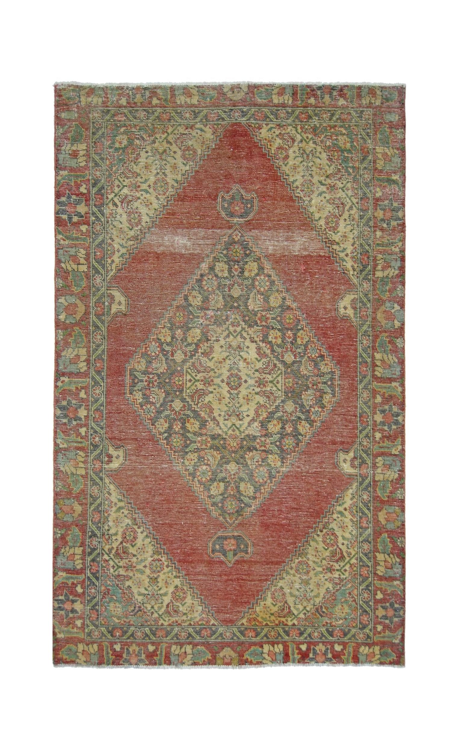 A vintage handmade Persian rug featuring a central diamond medallion on a red field.