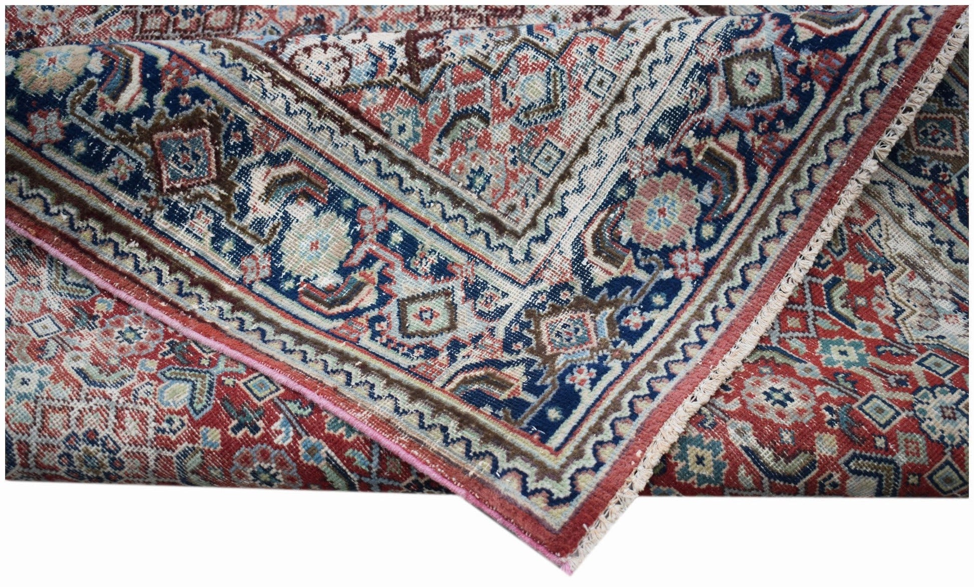 A handwoven vintage Persian rug featuring intricate geometric patterns in red, blue, and cream.