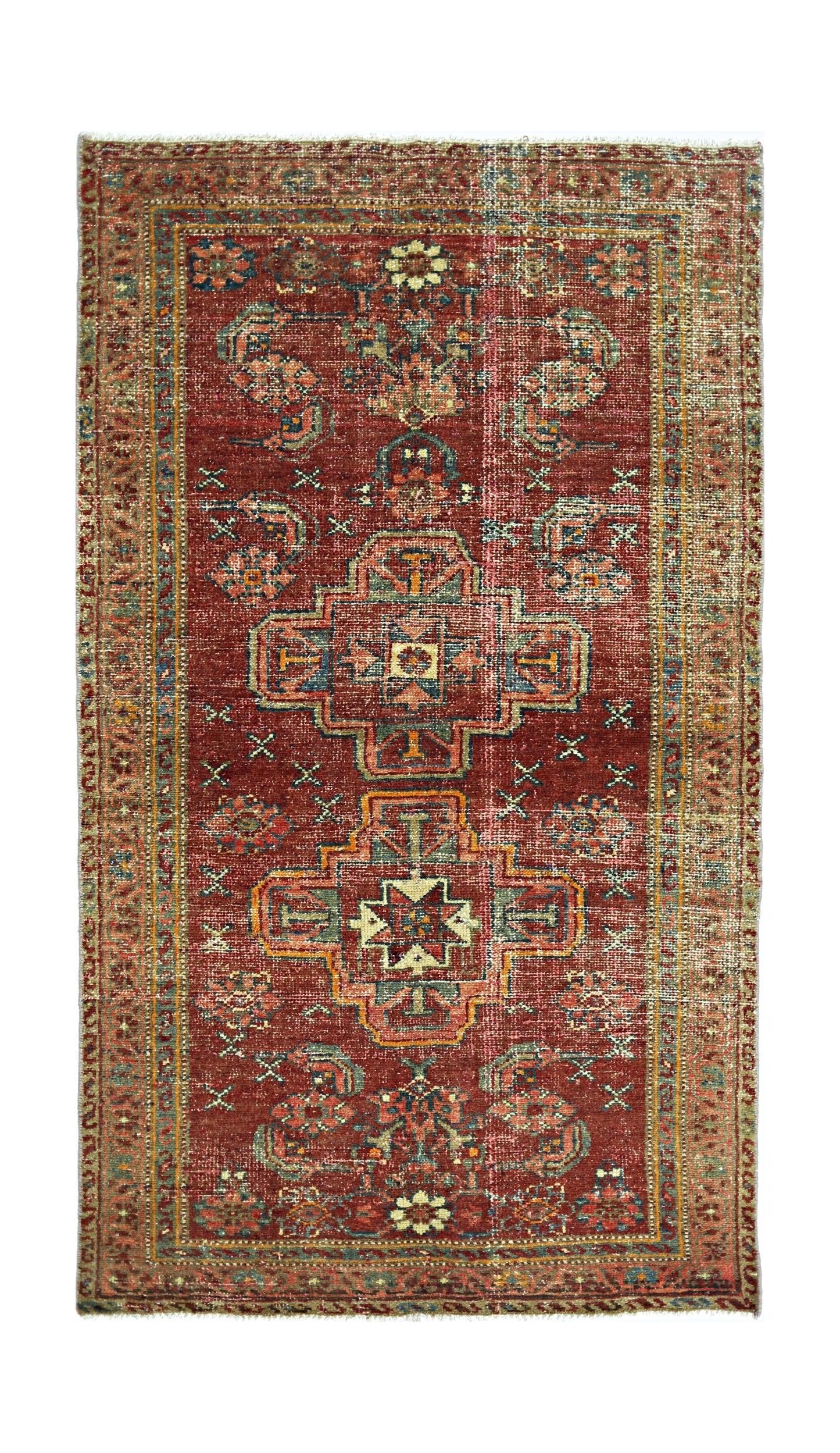 A rectangular vintage Persian rug featuring a geometric medallion pattern in red and blue tones.