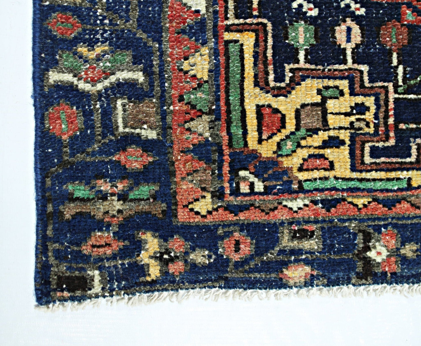 A vintage Persian Hamadan rug featuring a geometric pattern in blue, red, and yellow wool.