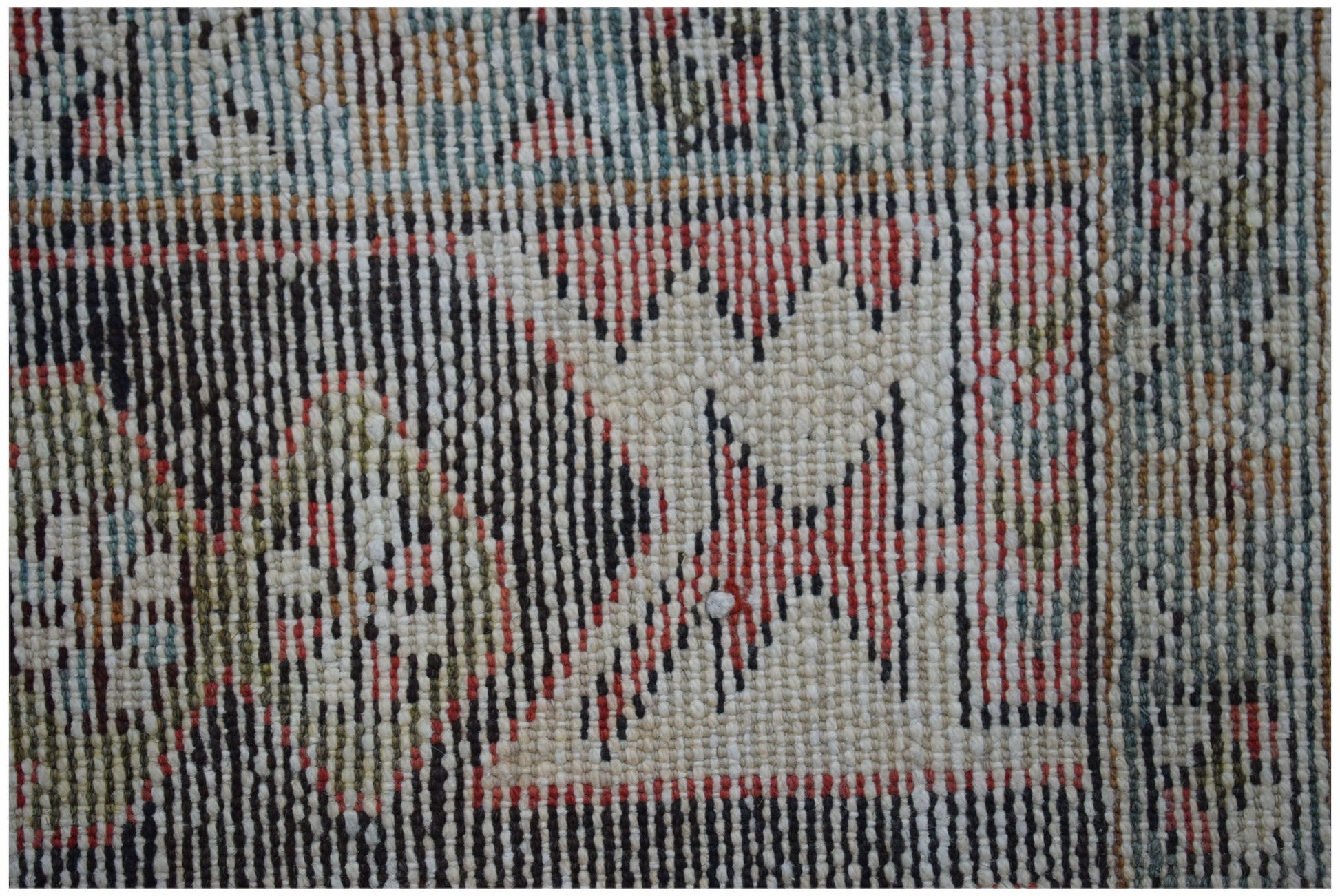 A close-up of a vintage Persian Hamadan rug featuring geometric patterns in red, black, and cream.