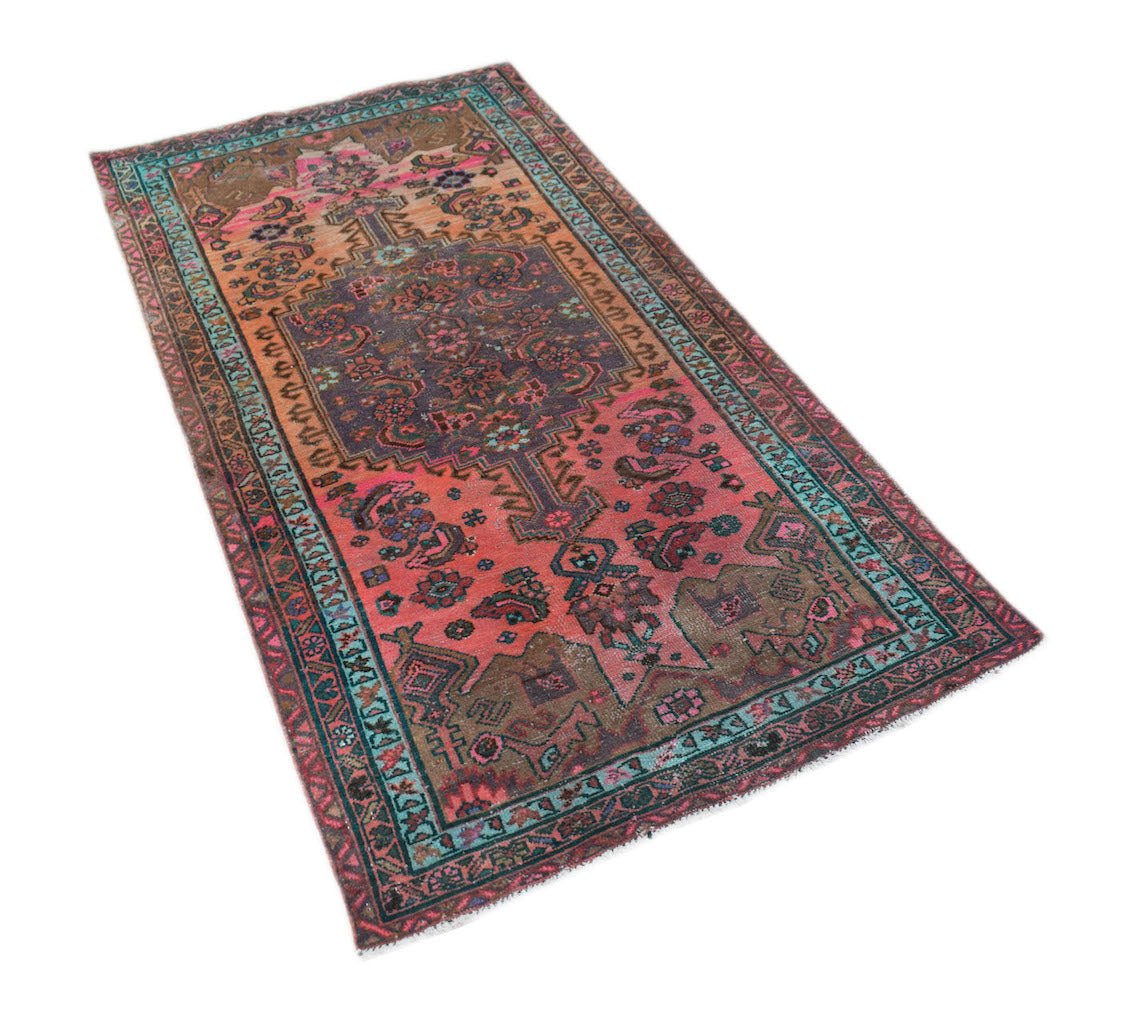 A rectangular vintage Persian rug featuring a central medallion with floral patterns in pink and blue.