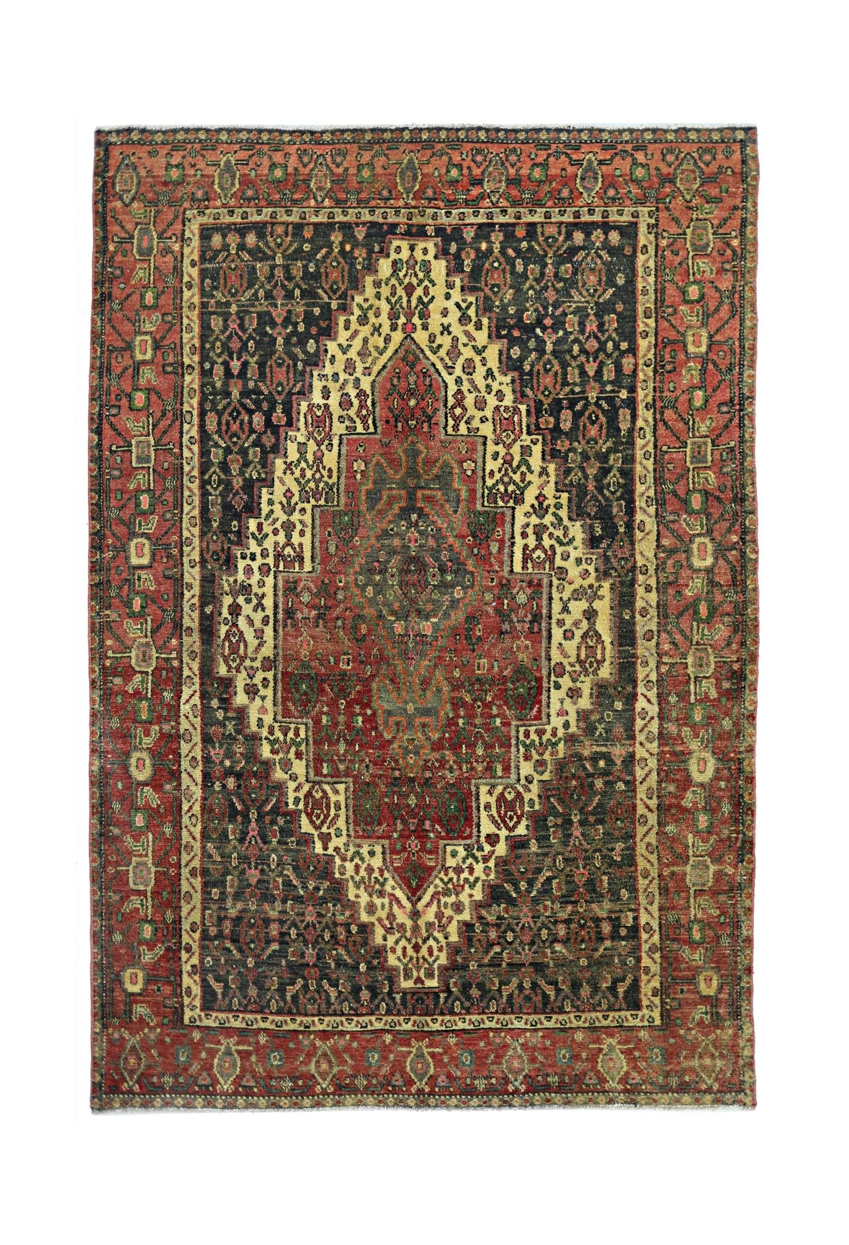 A vintage Persian Sanandaj rug featuring a central diamond medallion on a dark patterned field.