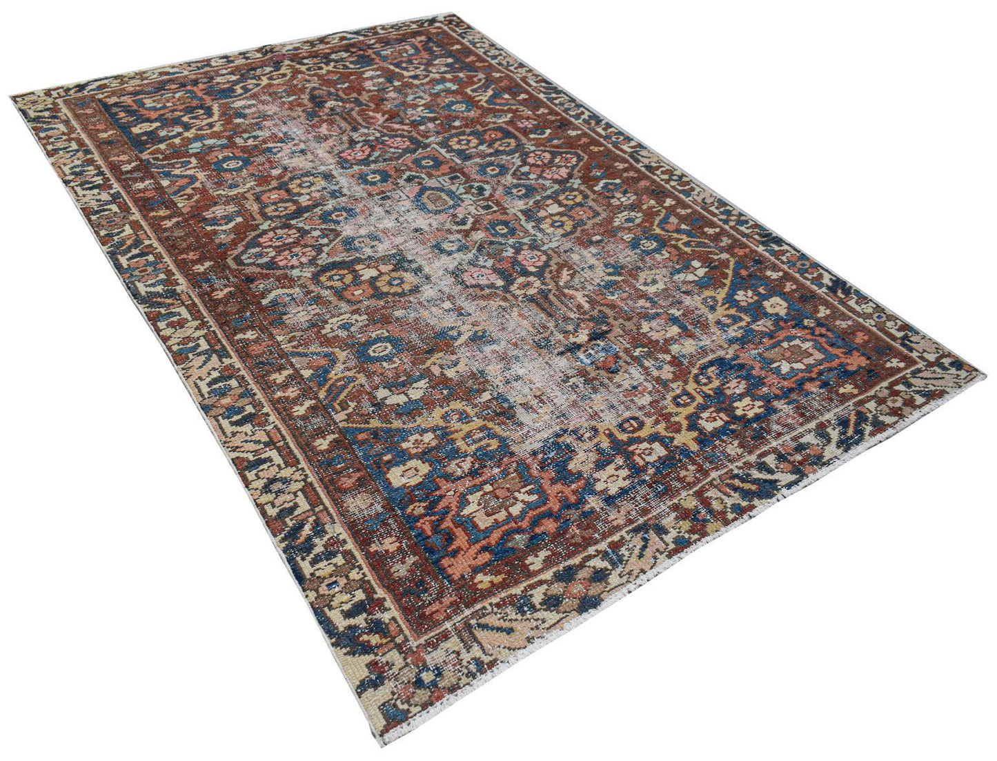 A rectangular vintage Persian rug featuring a distressed floral pattern in red and blue tones.