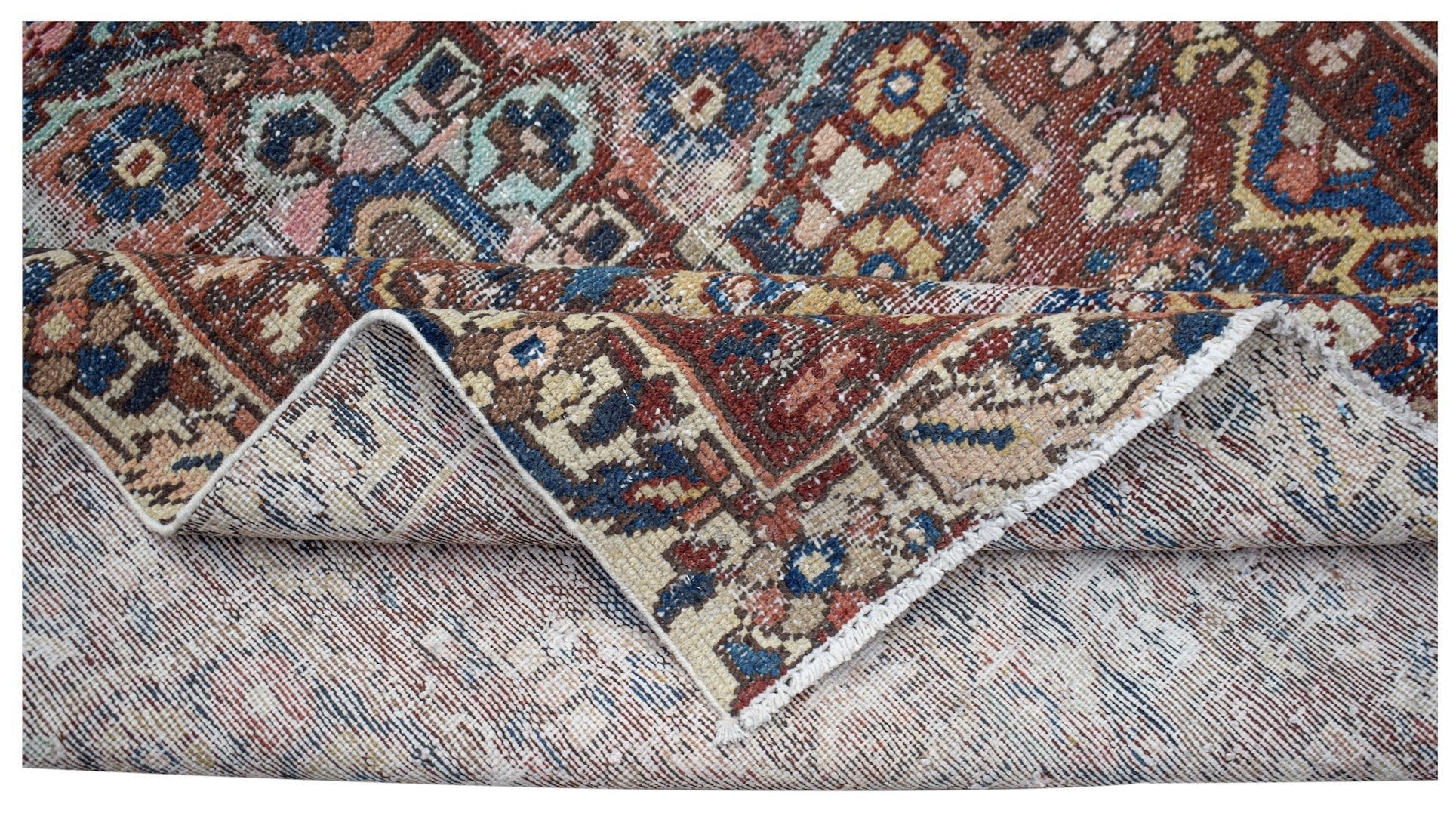 A handwoven vintage Persian rug featuring a geometric pattern in red, blue, and beige tones.