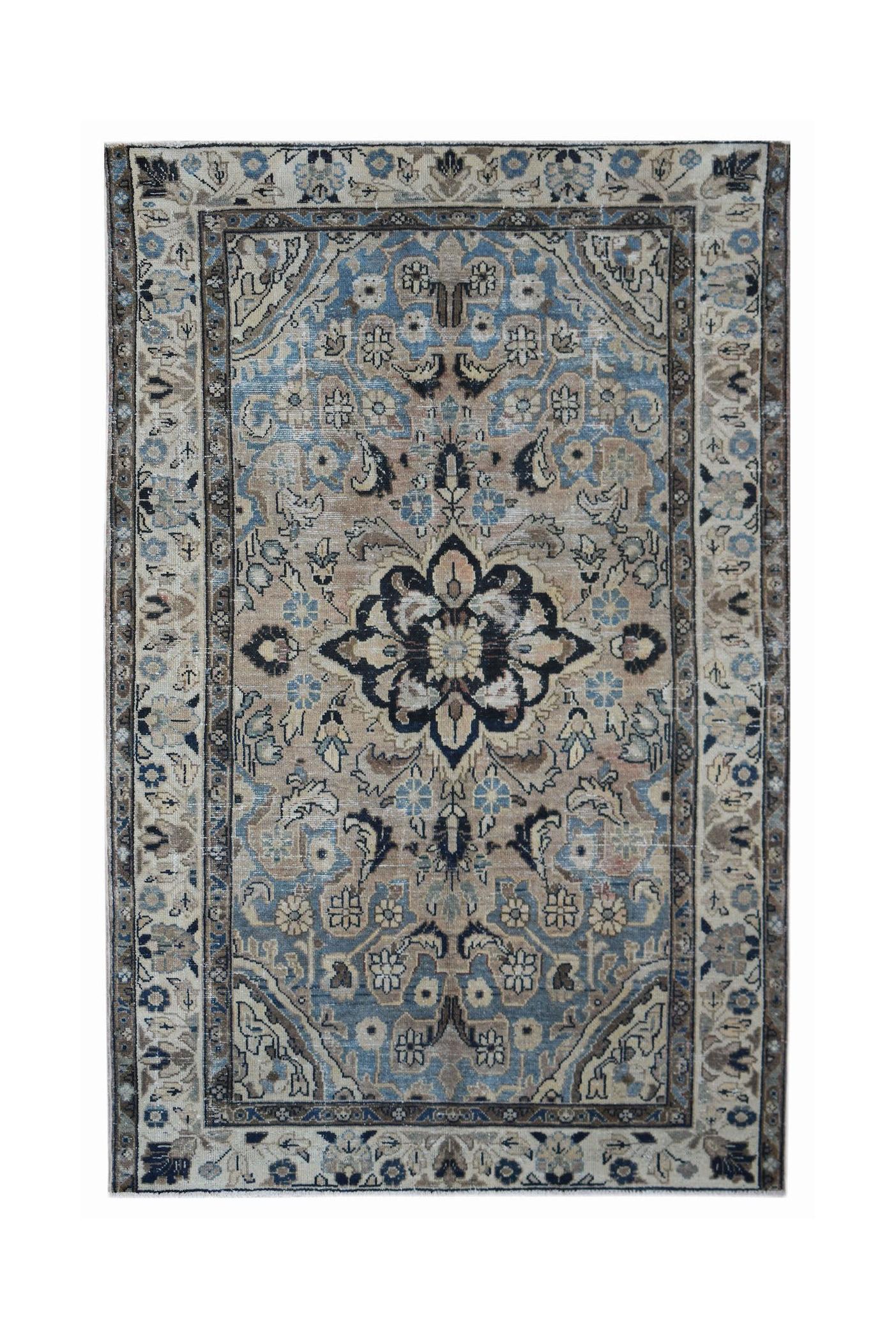 A vintage handwoven Persian Sarouk rug featuring a central floral medallion in blue and beige.