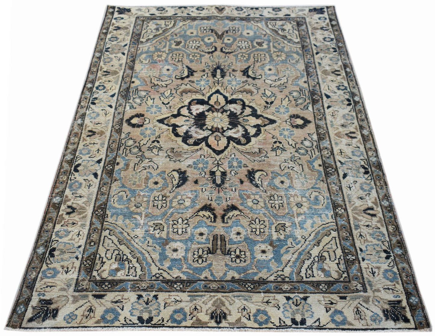 A vintage handwoven Persian Sarouk rug featuring a floral medallion in blue and beige tones.