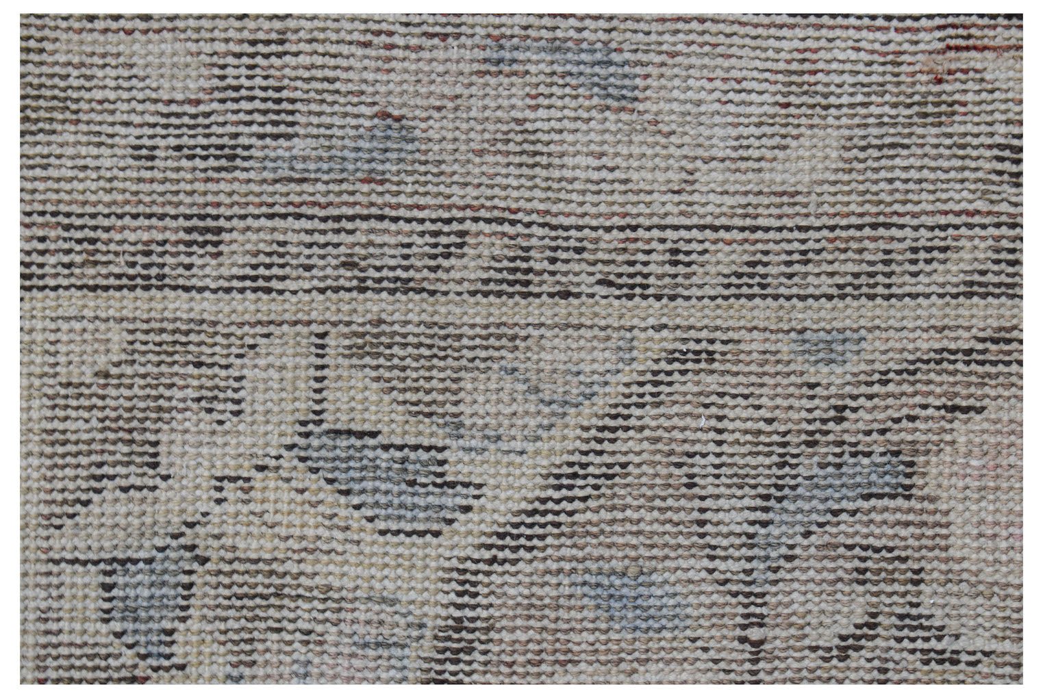 Vintage Persian rug with a faded pattern in neutral tones.