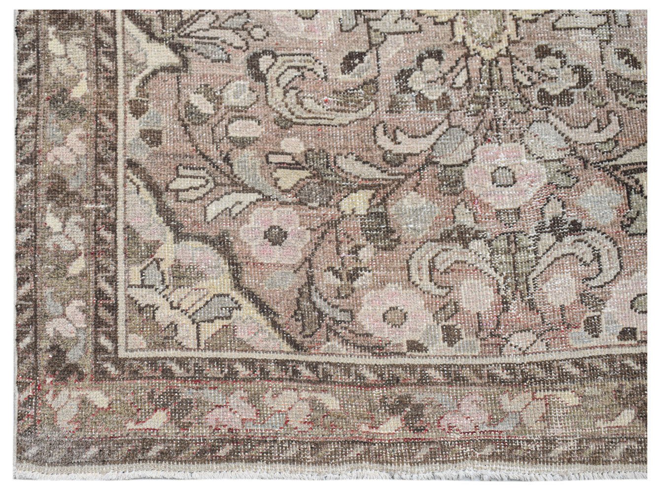 Vintage Persian rug with floral patterns in muted pink and brown tones.