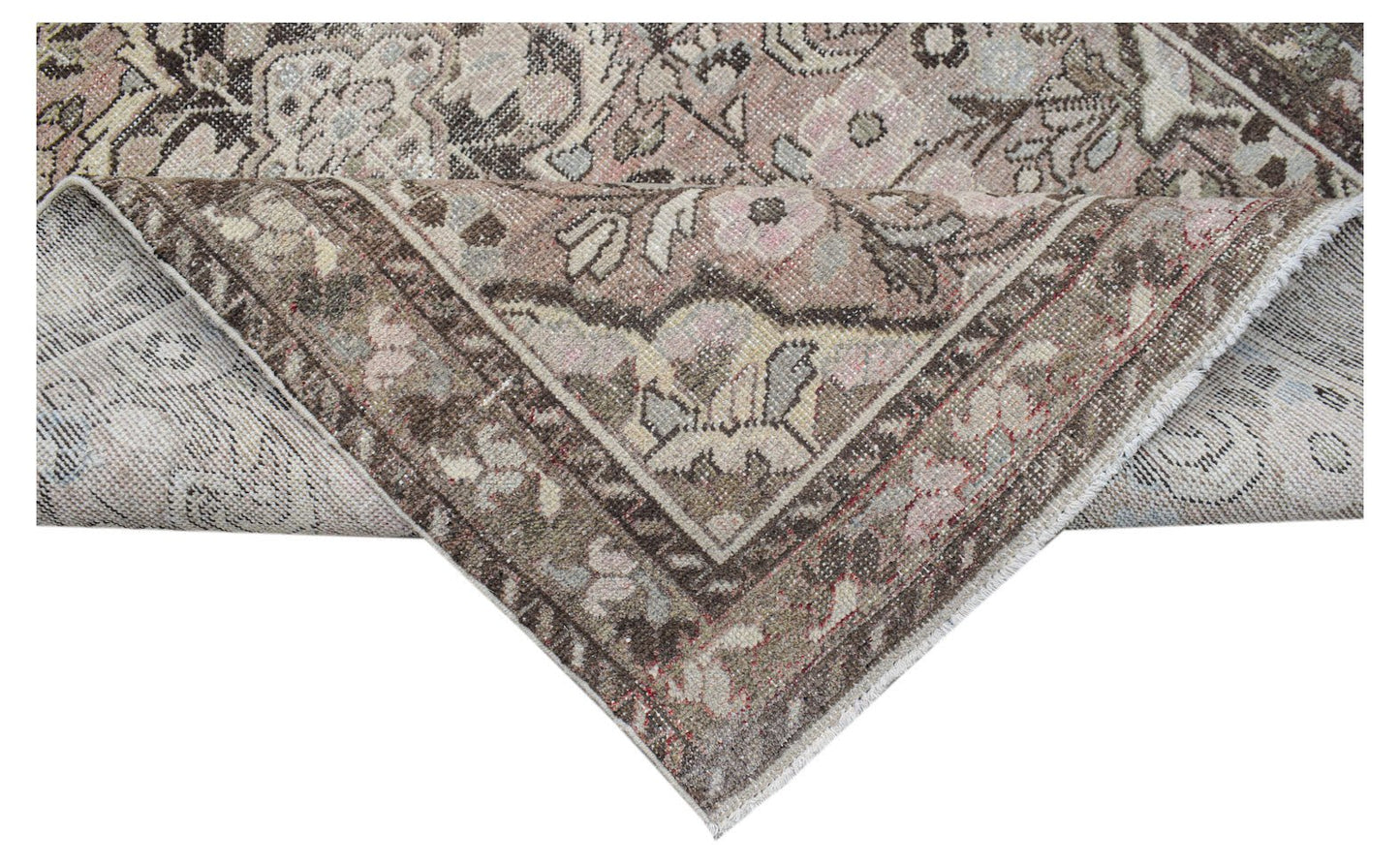 A vintage handwoven Persian rug featuring a faded floral pattern in muted brown and pink tones.