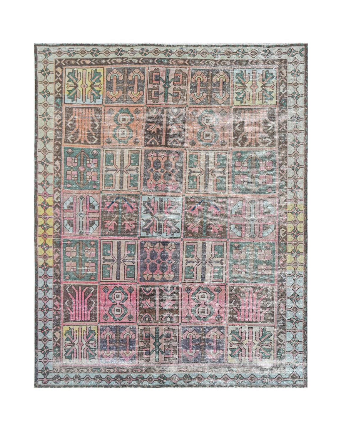 Vintage Persian rug with a patchwork of geometric patterns in muted pink, green, and brown.