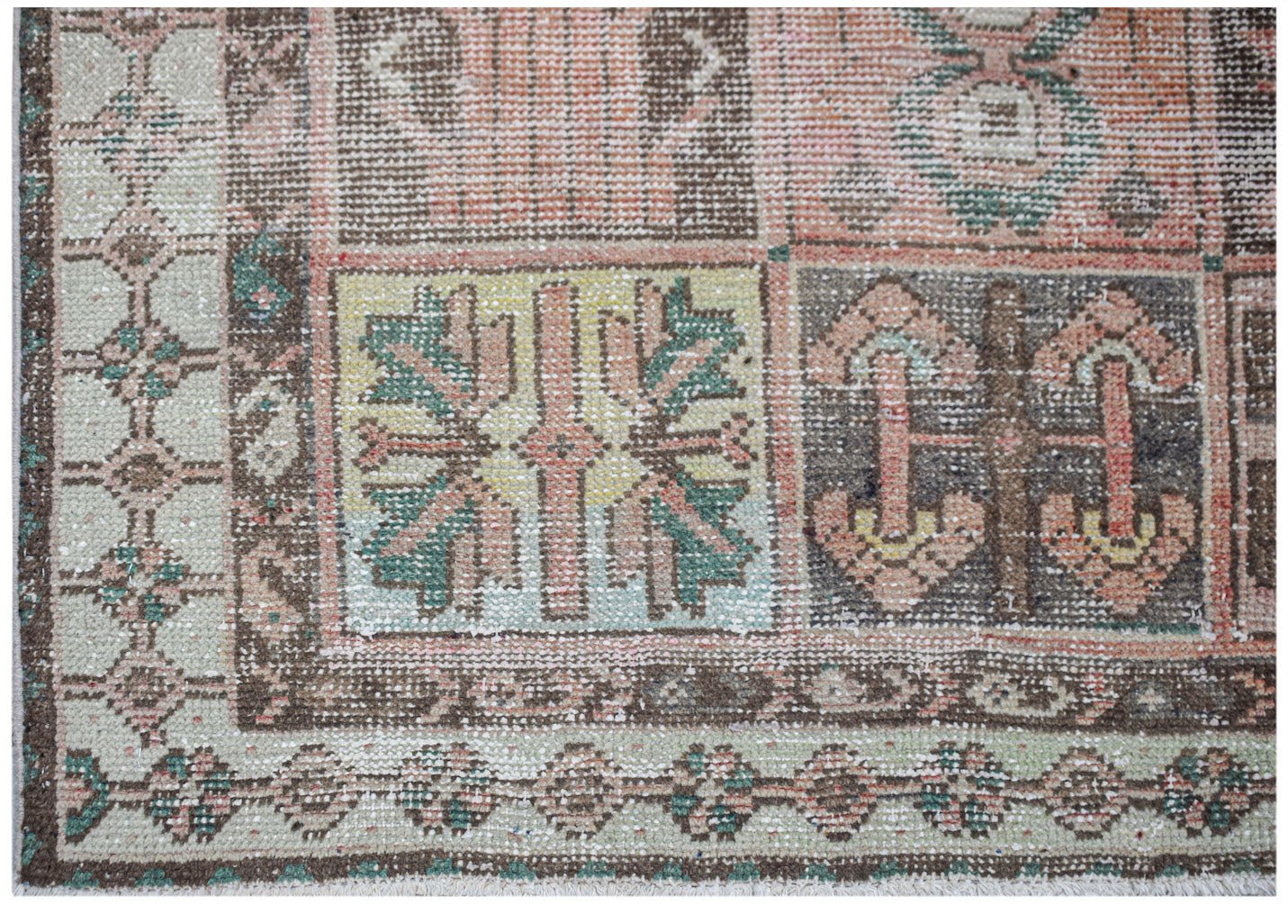 Vintage Persian rug with geometric patterns in muted colors.